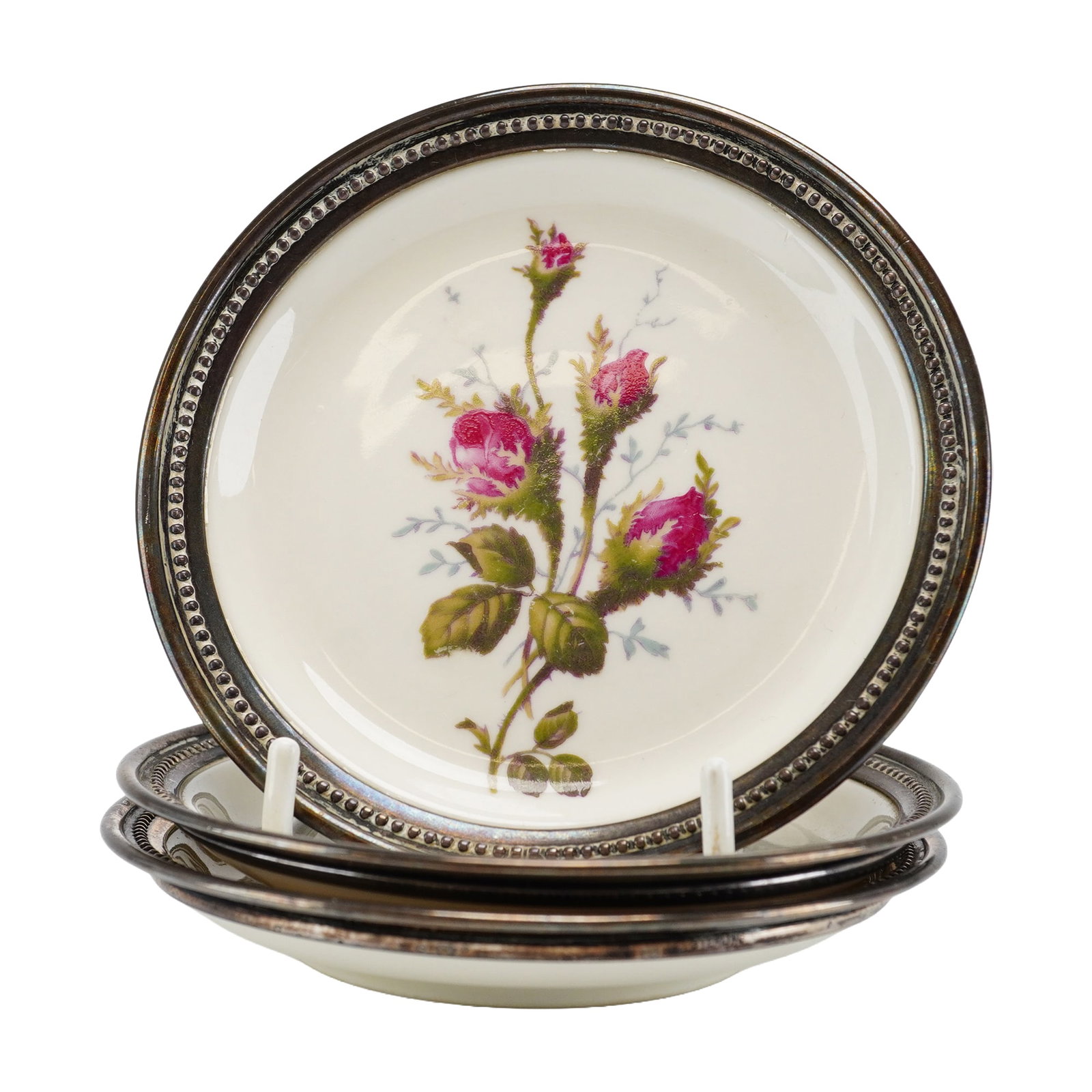 Set of Three Rosenthal Moss Rose Porcelain Plates with Beaded Sterling Silver Rims: A set of four circular porcelain coaster plates or small nut dishes produced by Rosenthal in the Moss Rose pattern. Each plate features a central polychrome transfer-decorated motif depicting pink ros