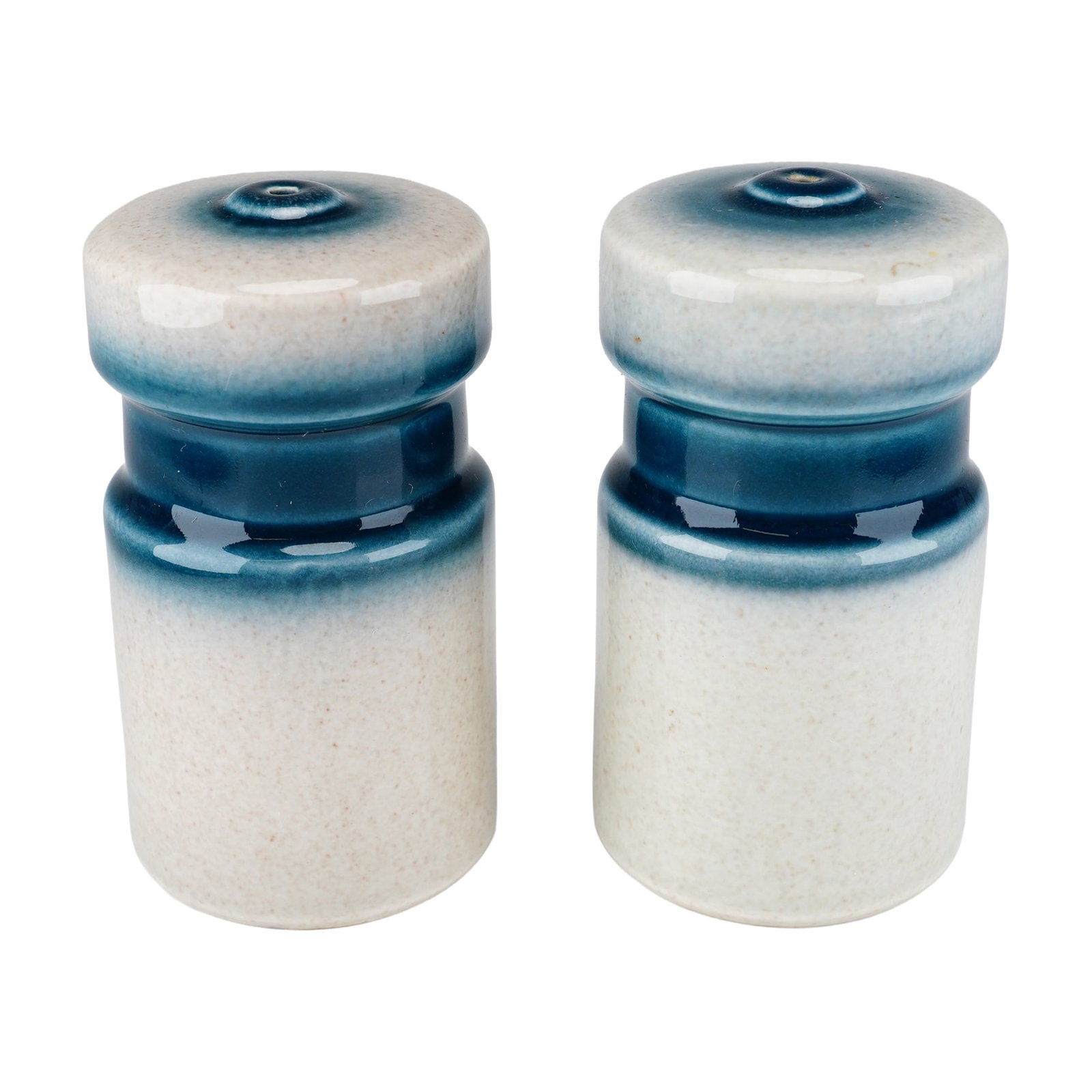 Pair of Wedgwood Blue Pacific Stoneware Salt and Pepper Shakers: This pair of stoneware salt and pepper shakers was manufactured by Wedgwood in England in the Blue Pacific pattern. The shakers feature a cylindrical body with a slightly flared, rounded top. The deco