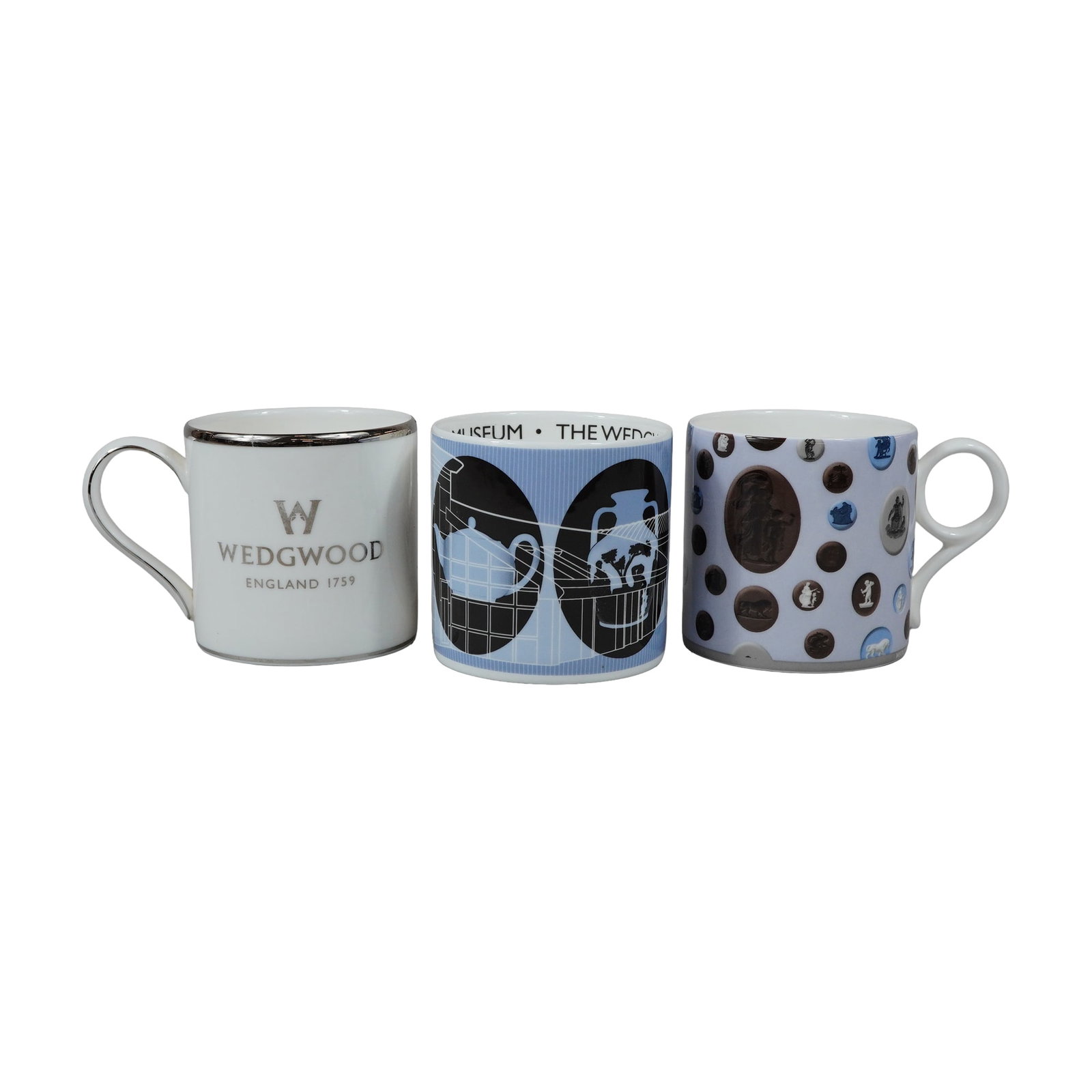 Three Wedgwood Bone China Commemorative and Decorative Mugs: A collection of three bone china mugs manufactured by Wedgwood in England. Each mug features a cylindrical form with a simple loop handle. The first mug was produced to celebrate the opening of the We