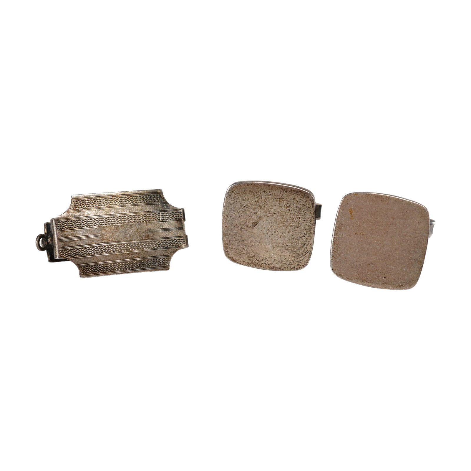 Three-Piece Sterling Silver Jewelry Group Including a Pair of Cufflinks and a Money Clip: A three-piece collection of men's sterling silver accessories consisting of a pair of cufflinks and one money clip. The money clip displays an Art Deco aesthetic with an engine-turned rectangular face