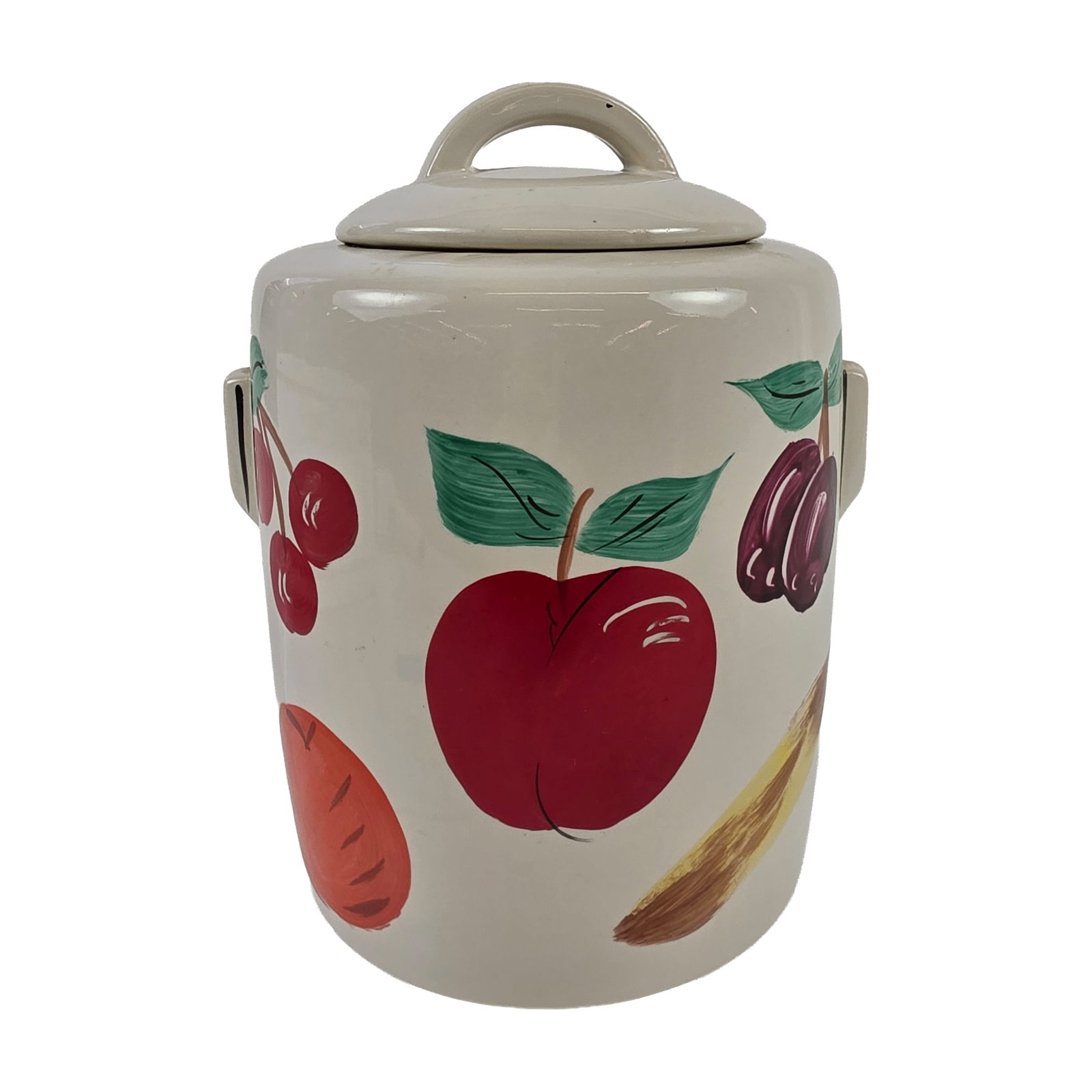 McCoy Ceramic Fruit Cookie Jar: Cookie jar in glazed earthenware, featuring a cylindrical body with two lug handles and a matching domed lid with a hoop-style handle. The exterior is decorated with hand-painted fruit and vegetable m