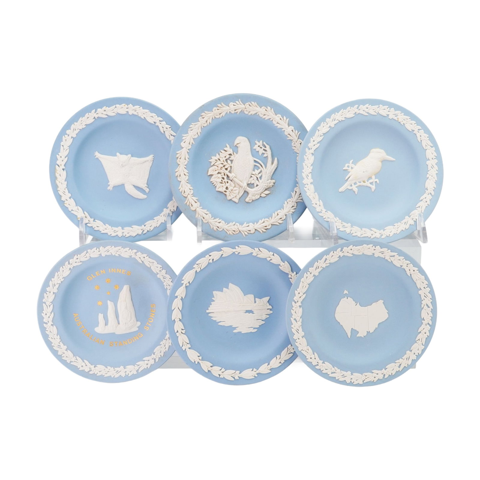 6pc Wedgwood Blue Jasperware Australian Themed Pin Dishes: This collection consists of six small round pin dishes manufactured by Wedgwood. Each dish is constructed from light blue jasperware, which is a matte unglazed stoneware, featuring white sprigged reli