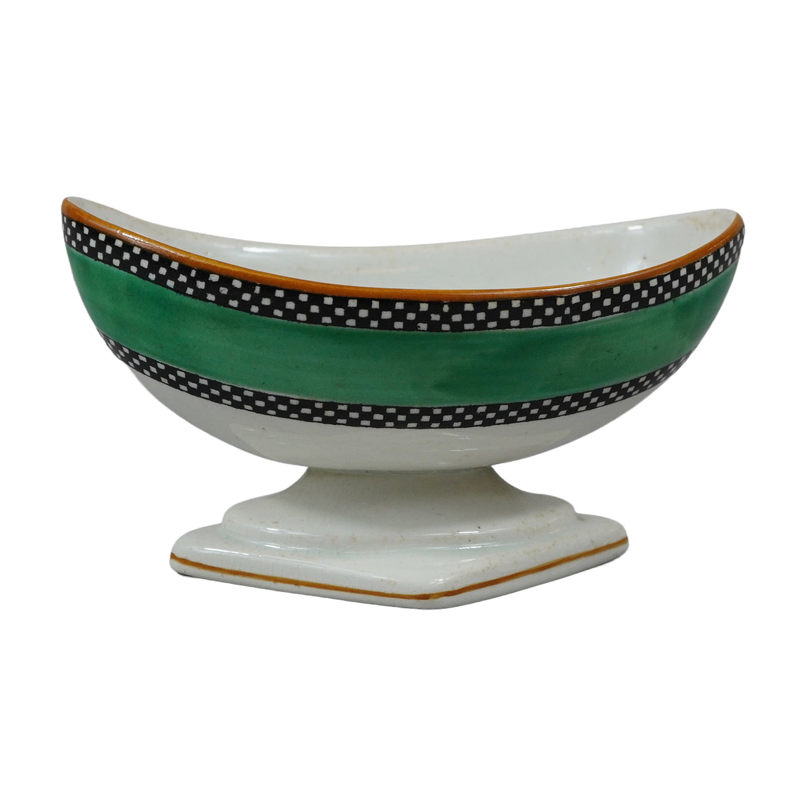 Wedgwood Heal and Son Chequer Border Footed Earthenware Dish: The earthenware vessel features a boat-shaped form mounted on a pedestal with a rhomboid-shaped base. Decoration consists of a wide, hand-painted green band around the midsection, bordered by two blac
