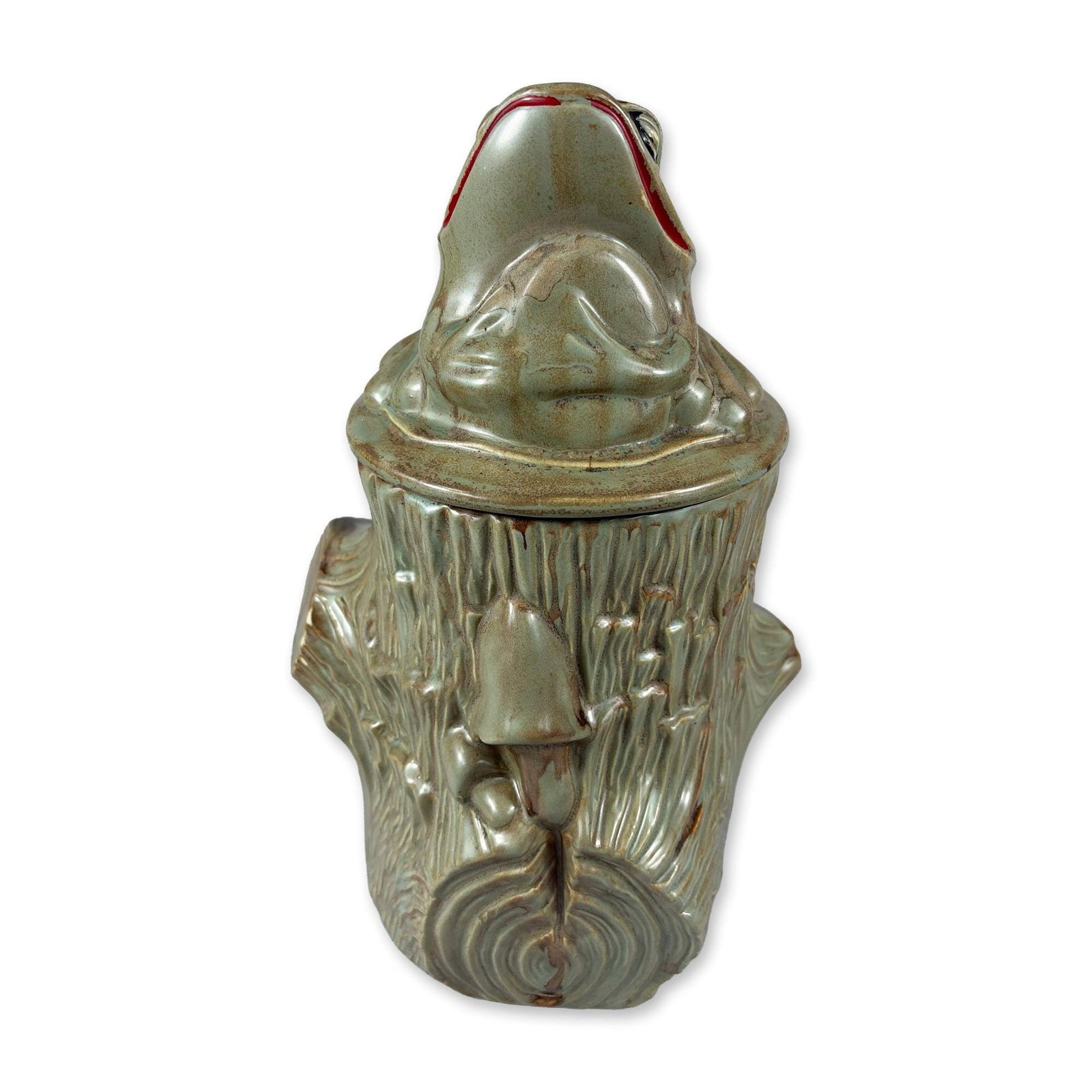 McCoy Ceramic Frog on Tree Stump Cookie Jar: Lidded ceramic jar in glazed earthenware, featuring a frog head lid on a body textured to resemble a vertical tree stump with bark and knot details. Finished in a mottled green and brown reactive glaz