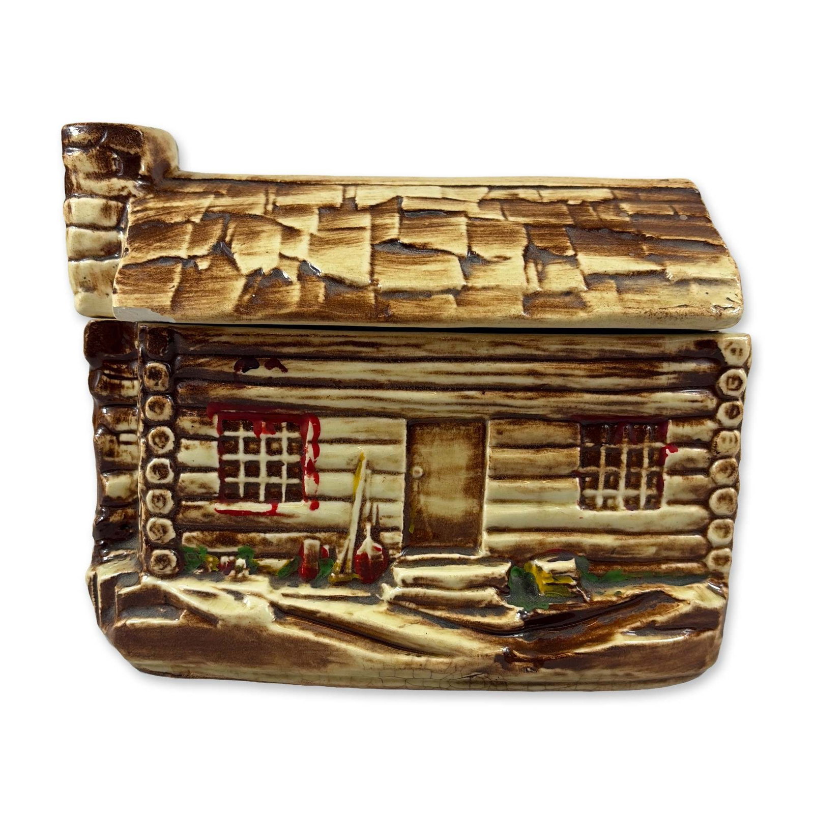 McCoy Ceramic Log Cabin Jar: McCoy USA pottery lidded jar in the form of a rustic log cabin. Constructed from glazed earthenware, the vessel features molded log walls, a shingled roof, and a fieldstone chimney. The decoration inc