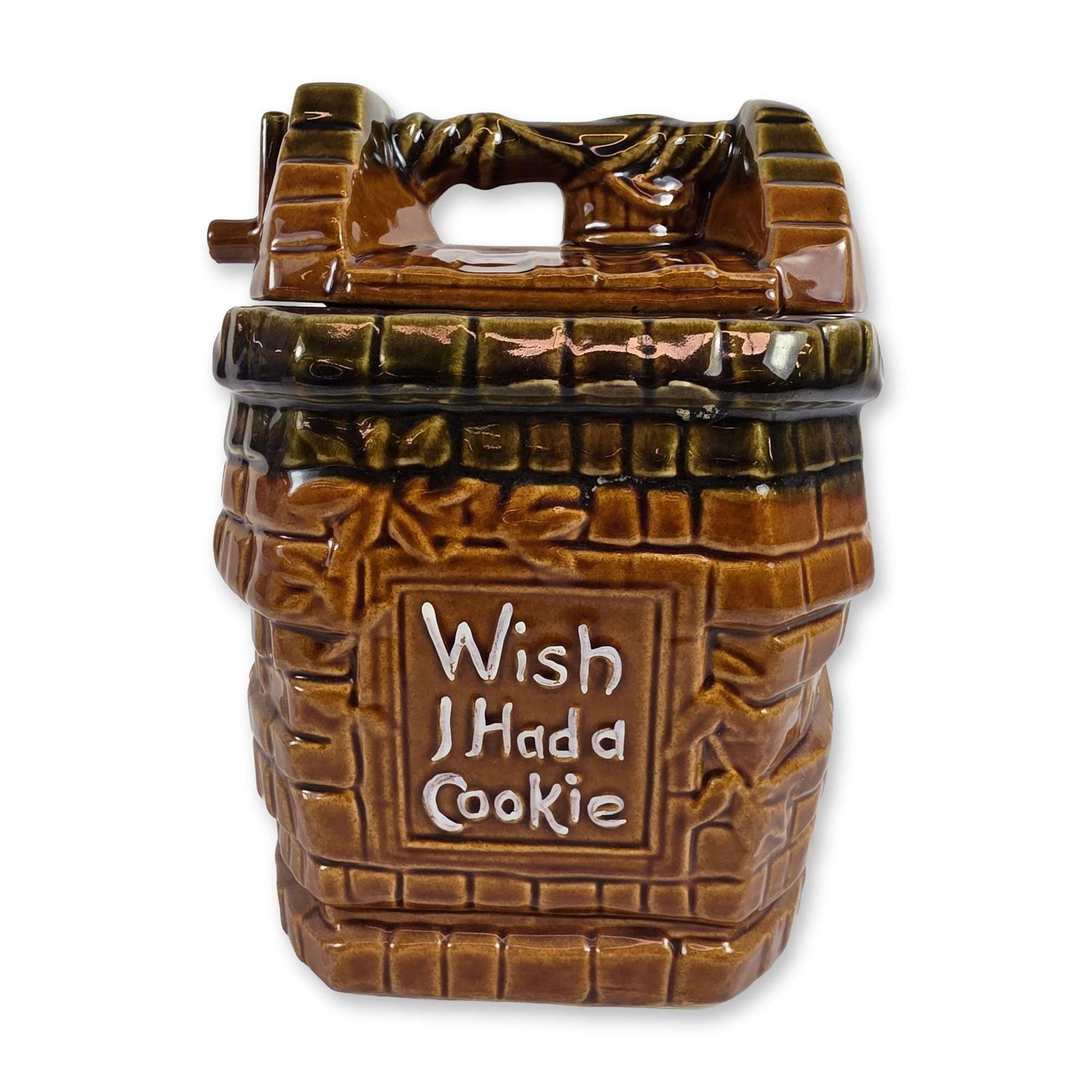 McCoy Ceramic Wishing Well Cookie Jar: McCoy Pottery (USA), mid-20th century. Cookie jar in glazed earthenware, designed in the form of a brick wishing well. The piece features a two-tone glaze in honey-brown and dark olive green with a re