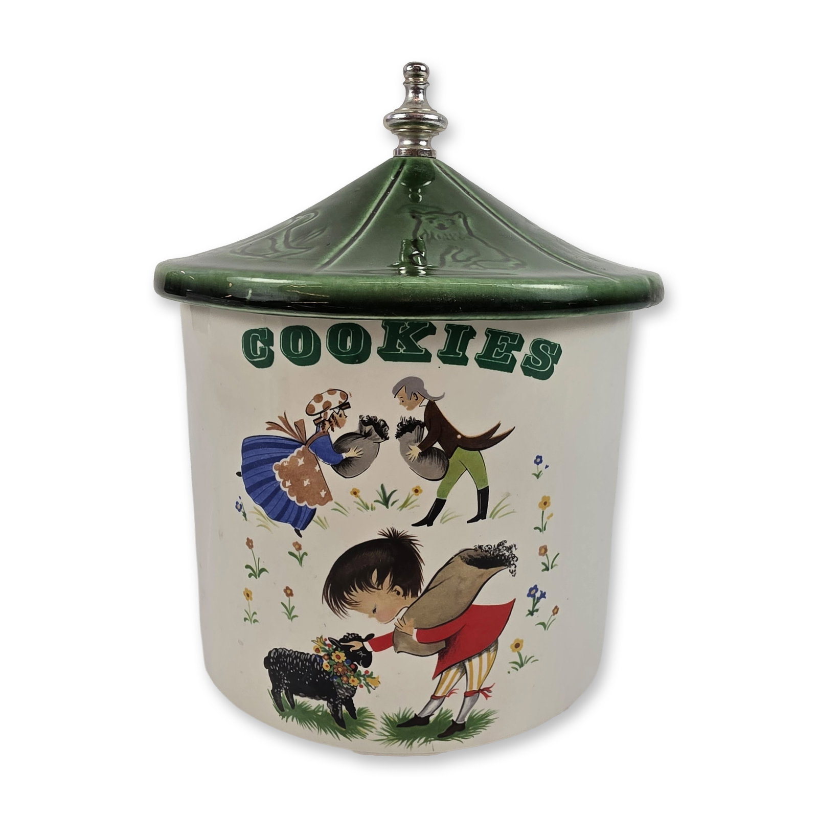 McCoy Pottery Nursery Rhyme Cookie Jar, Baa Baa Black Sheep: Ceramic cookie jar with matching lid, likely from the Nursery Rhyme series. The cylindrical earthenware body features a cream glaze with a vertical green label reading COOKIES and a transfer-printed s