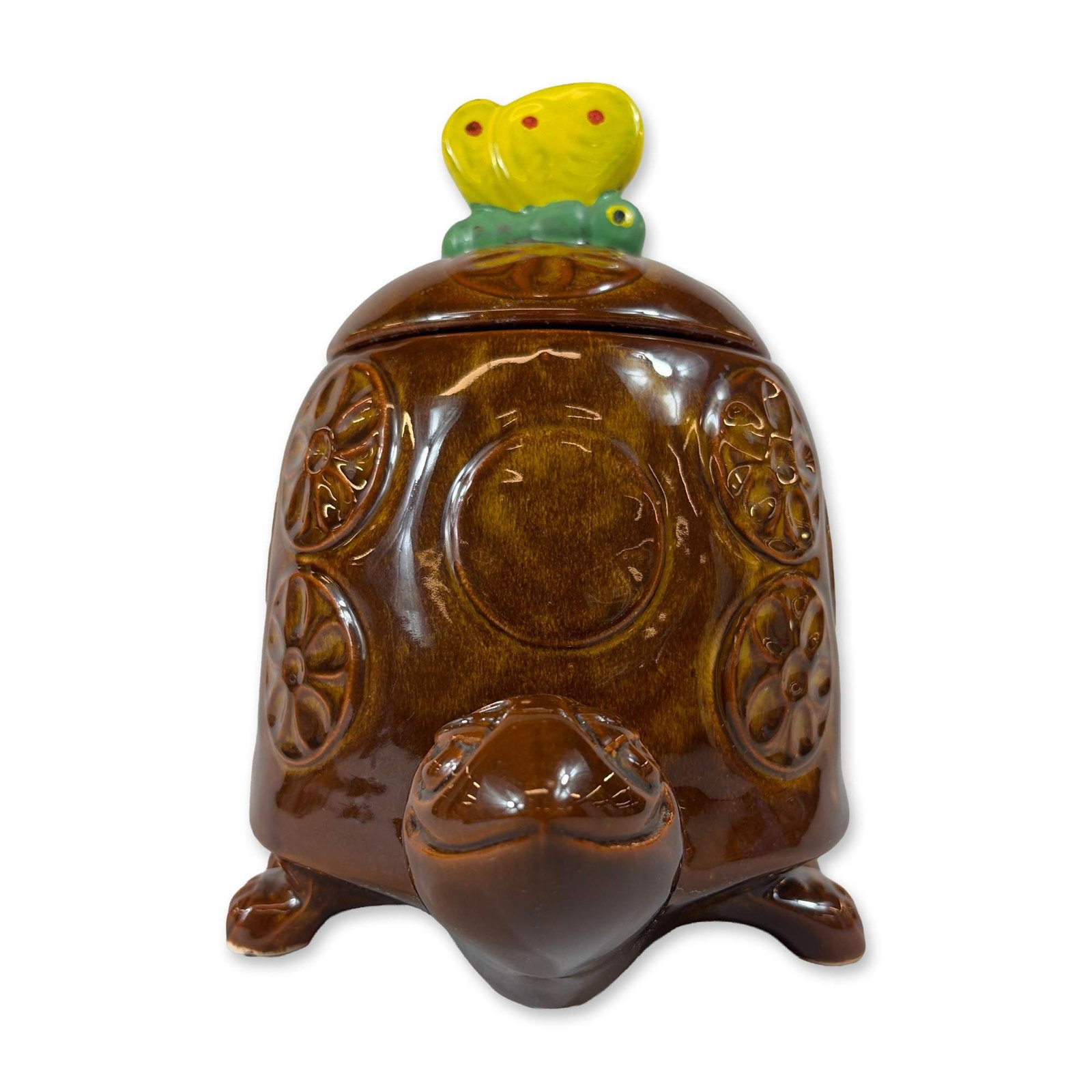 McCoy Tommy Tortoise Cookie Jar: McCoy Pottery Tommy Tortoise lidded cookie jar in glazed earthenware, featuring a turtle form shell decorated with molded floral rosettes. The piece is finished in a glossy brown glaze with tonal vari