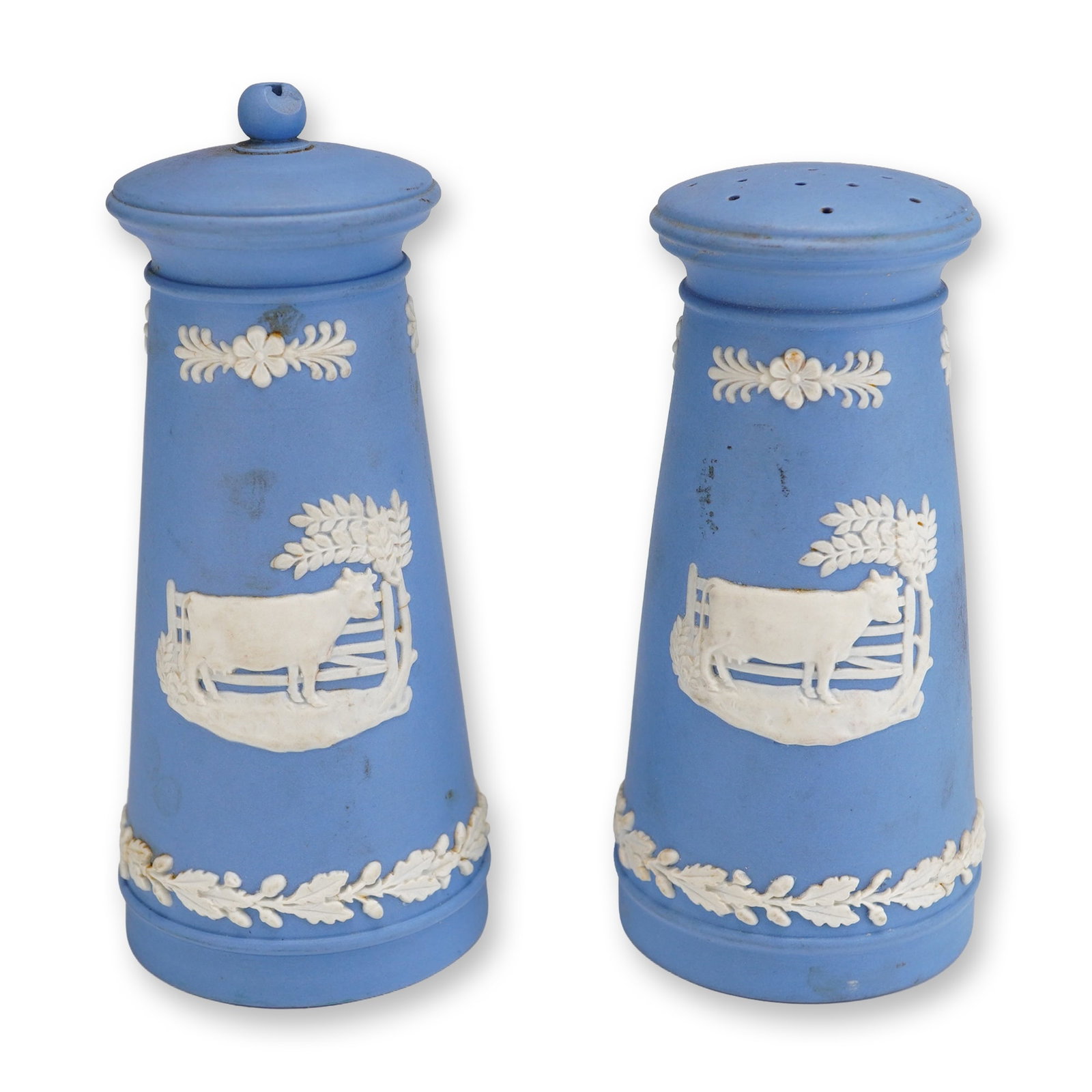 A Pair of Wedgwood Blue Jasperware Cow & Gate 50th Anniversary Salt and Pepper Shakers, ca. 1954: This pair of Wedgwood Jasperware salt and pepper shakers is crafted in pale blue matte-finished stoneware with white bas-relief sprigged decoration. Attributed to circa 1954, the set was produced as a