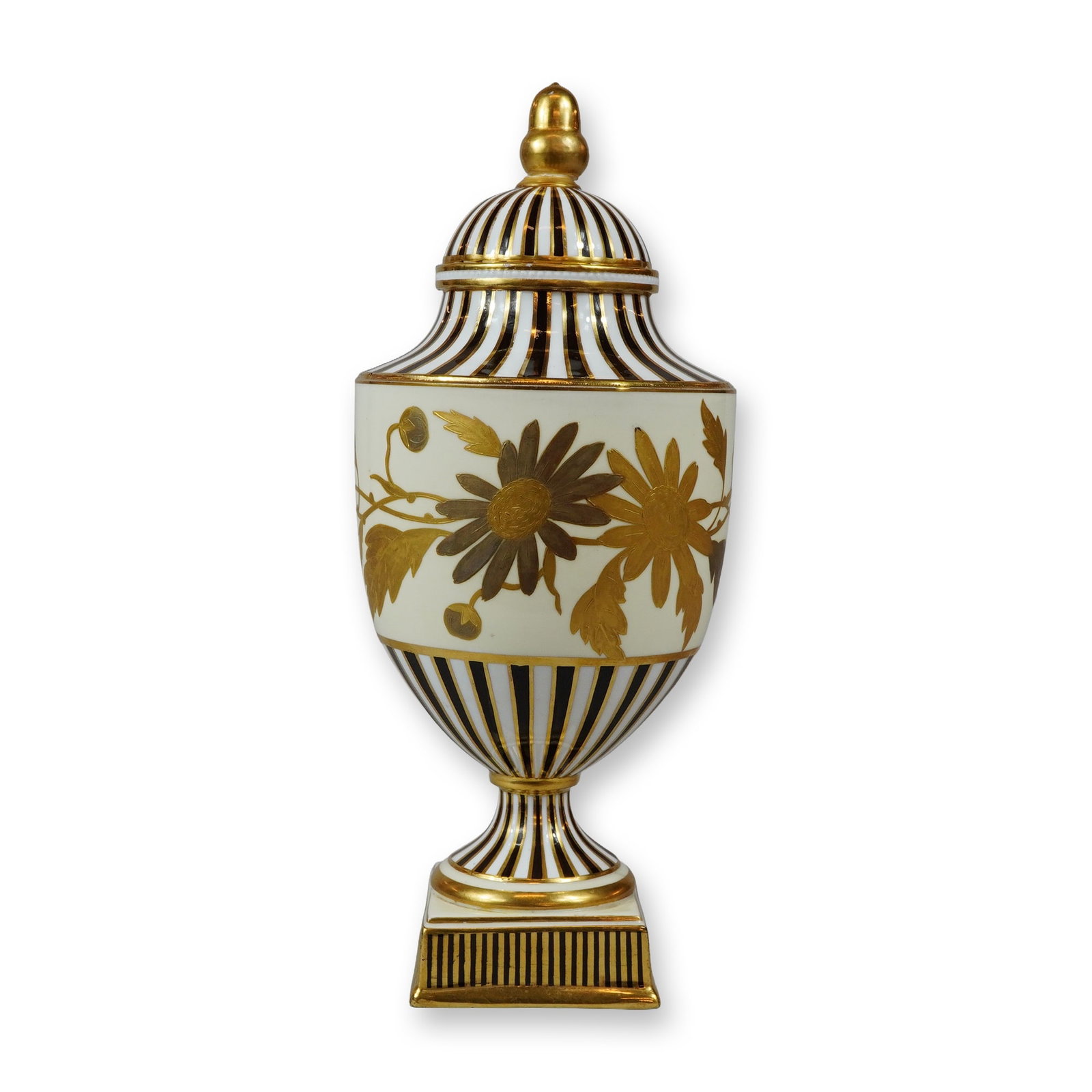 Wedgwood Black and Gilt Floral Motif Covered Urn: A lidded pedestal urn crafted from hard-paste porcelain. The vessel features a classical ovoid body mounted on a waisted circular foot, supported by a stepped square pedestal base. It includes a match