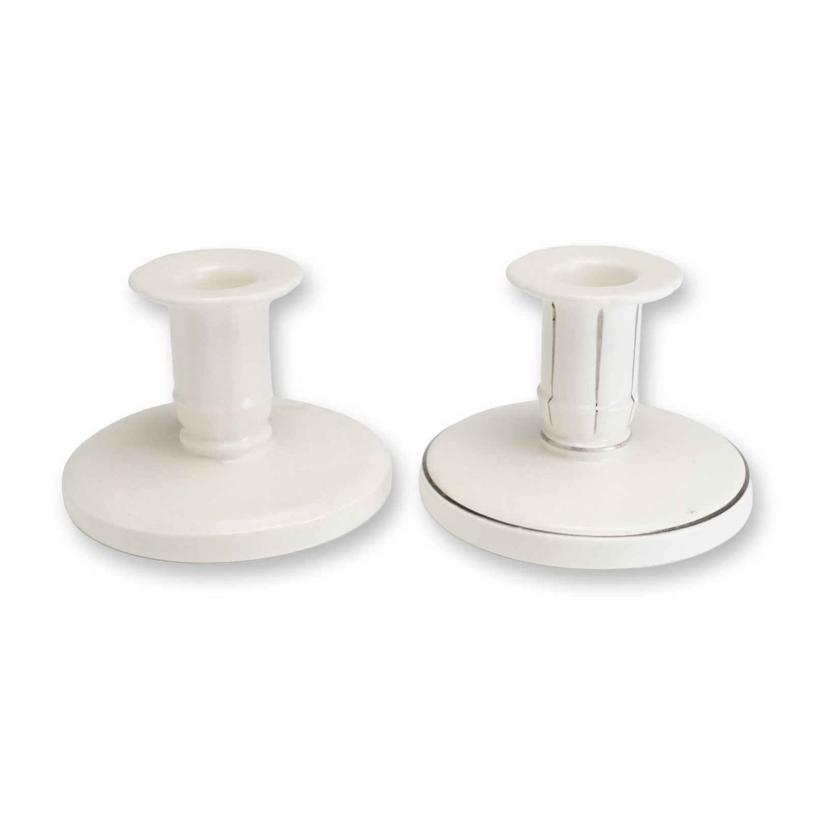 2pc Keith Murray for Wedgwood Ceramic Candle Holders: A pair of Art Deco fine earthenware candle holders designed by Keith Murray for Wedgwood. The pair consists of one example in a matte cream glaze and one sample prototype featuring silver-toned luster