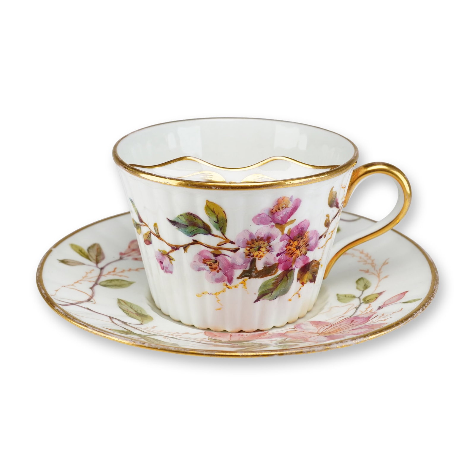 Wedgwood Porcelain Floral Gilded Ribbed Mustache Cup and Saucer Set: A Victorian era porcelain mustache cup and saucer set manufactured by Wedgwood. The set is composed of fine bone china featuring a vertically ribbed or fluted body. The cup is equipped with an integra