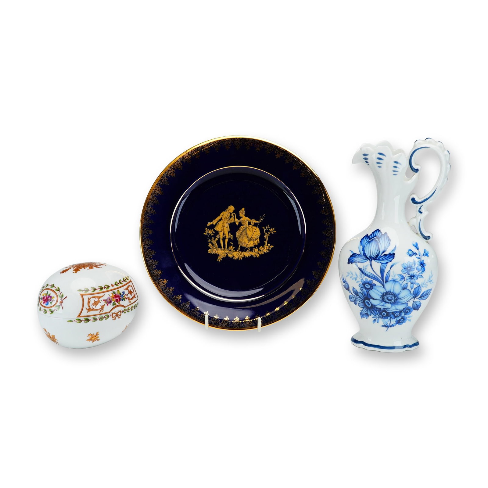 Lot of 3 Limoges France Porcelain Pieces including Plate, Pitcher, and Egg Trinket Dish: This lot comprises three decorative porcelain items manufactured in Limoges, France. The first item is a circular display plate featuring a deep cobalt blue glaze, known as Bleu de Four. The center is