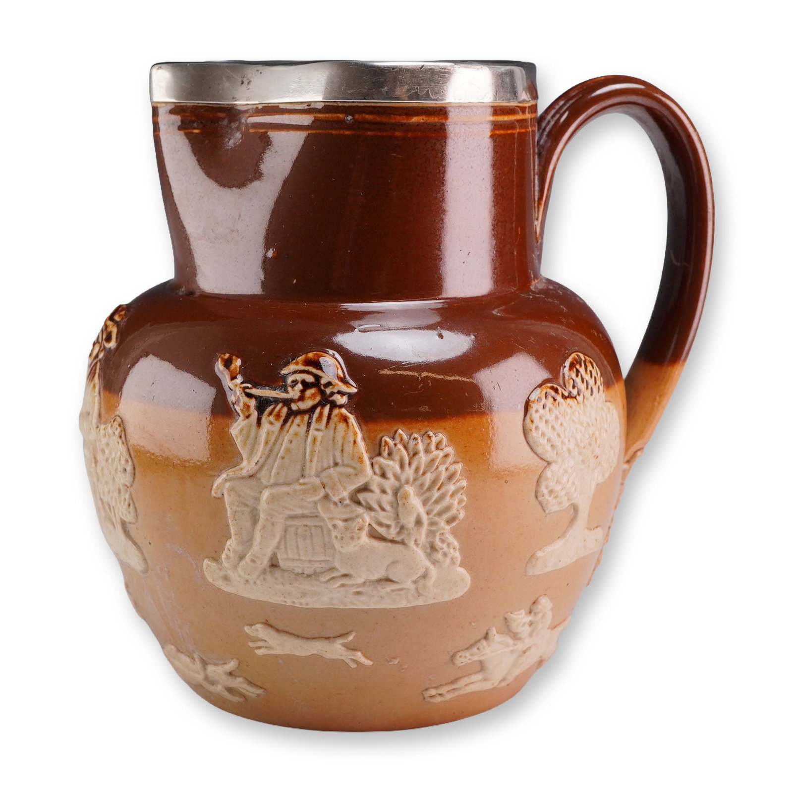 Doulton Lambeth Stoneware Harvest with Sterling Silver Rim Jug: Doulton Lambeth, England. Small salt-glazed stoneware pitcher from the Harvest series, featuring a two-tone brown and tan body with applied white sprigged reliefs. The decoration depicts traditional r