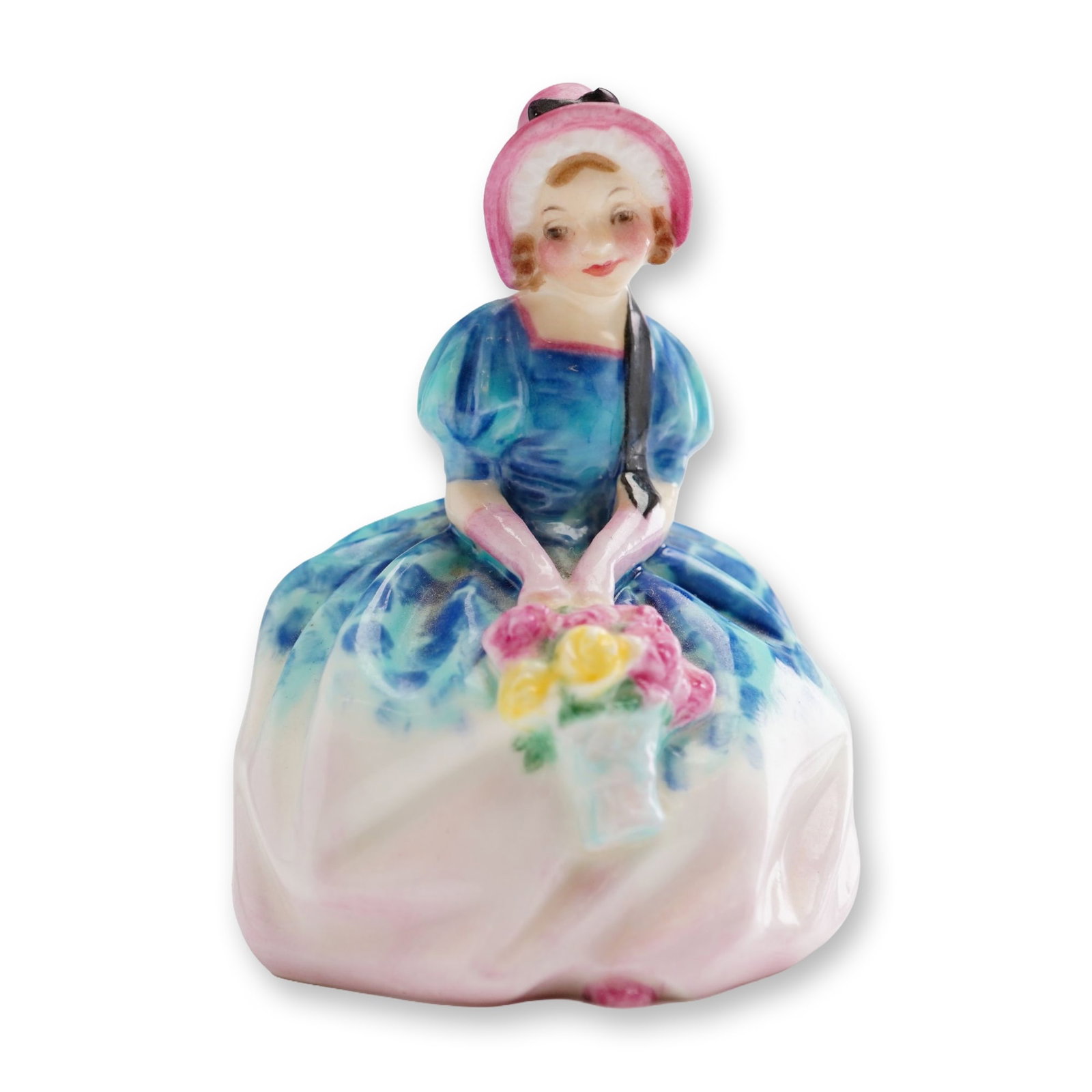 Royal Doulton Miniature Figurine, Monica M72: A hand painted porcelain portraying a young woman seated gracefully, holding a bouquet of flowers while wearing a bright pink bonnet with a trailing black ribbon. Handwritten M number. Royal Doulton b