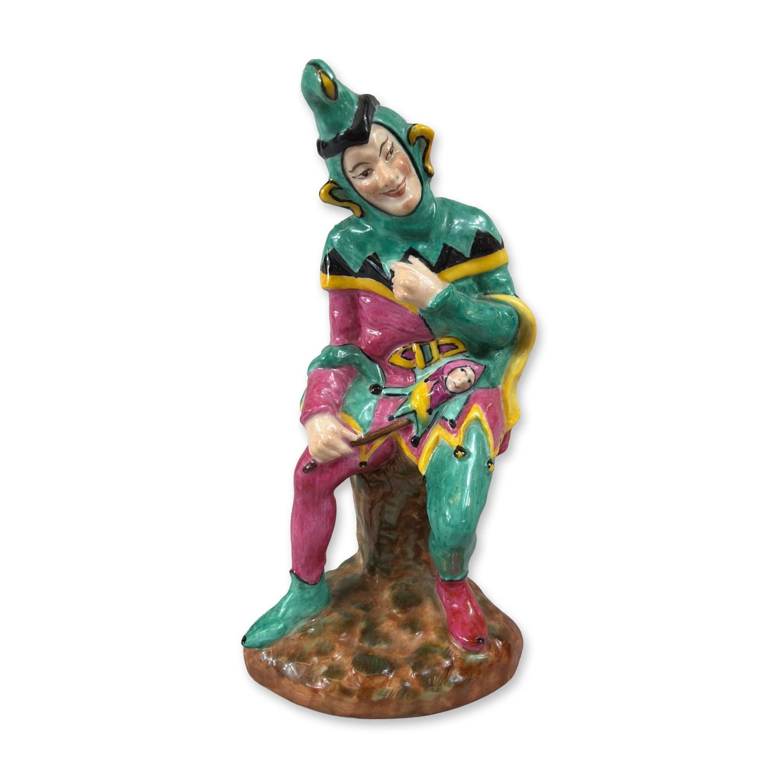 Coalport Bone China Jester Figurine: Coalport bone china figurine titled Jester, manufactured in England. The glazed porcelain figure depicts a court jester leaning against a rustic tree stump, dressed in a green tunic and cowl with yell