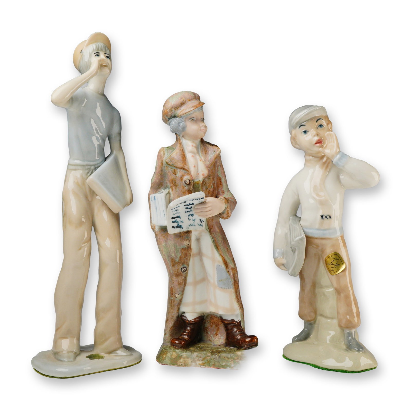 Three Spanish Glazed Porcelain Figural Statuettes of Newspaper Sellers: A trio of glazed porcelain figural statuettes depicting newspaper sellers, likely mid-to-late 20th century Spanish production. The figures are rendered in a realistic style with a high-gloss glaze and