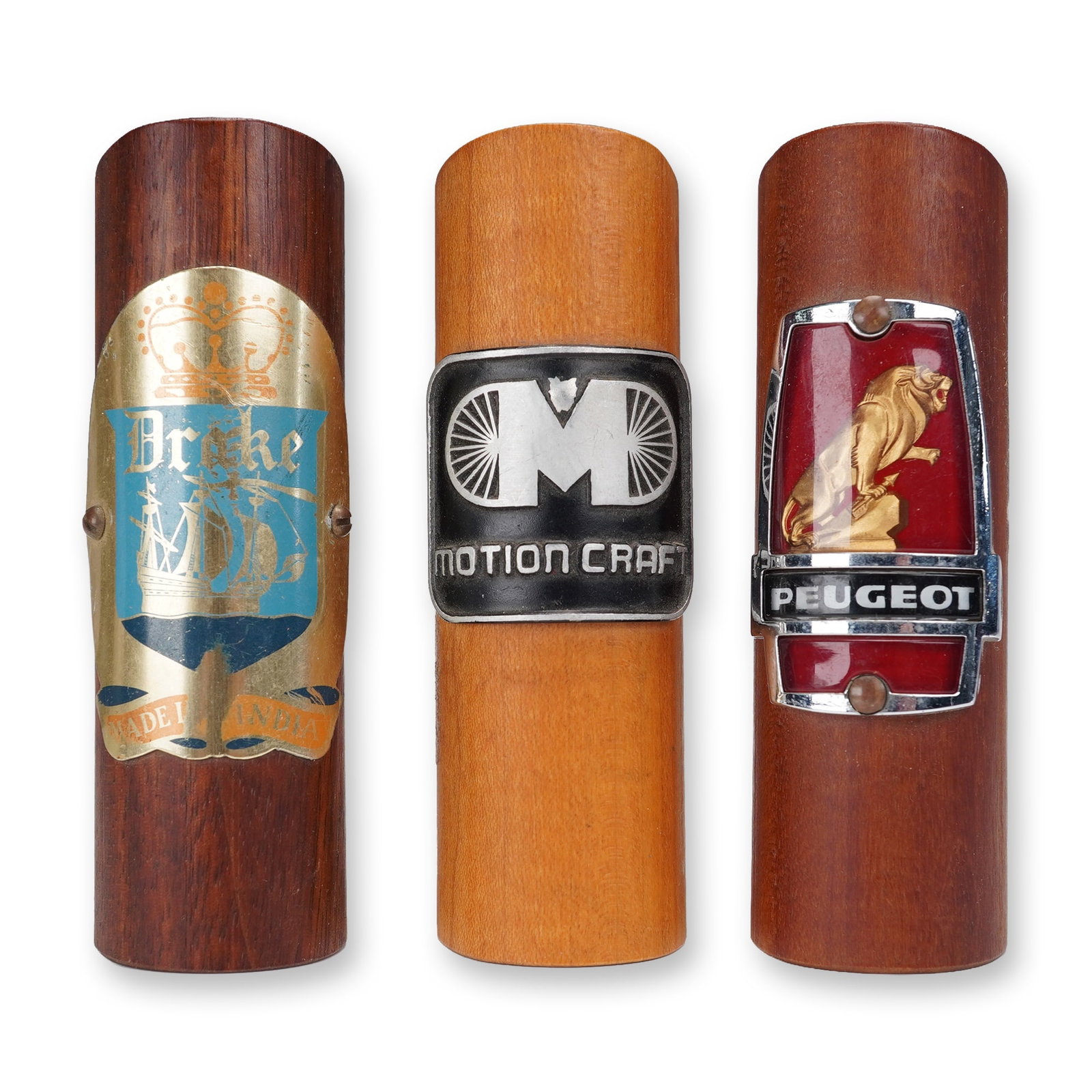 3pc Ralph W. Rogers Wooden Vehicle Emblem Displays: Set of three handcrafted wooden display blocks by Ralph W. Rogers of Lebanon, New Hampshire, featuring vintage vehicle emblems. Includes badges for Peugeot, Motion Craft, and Drake. Each block is stam