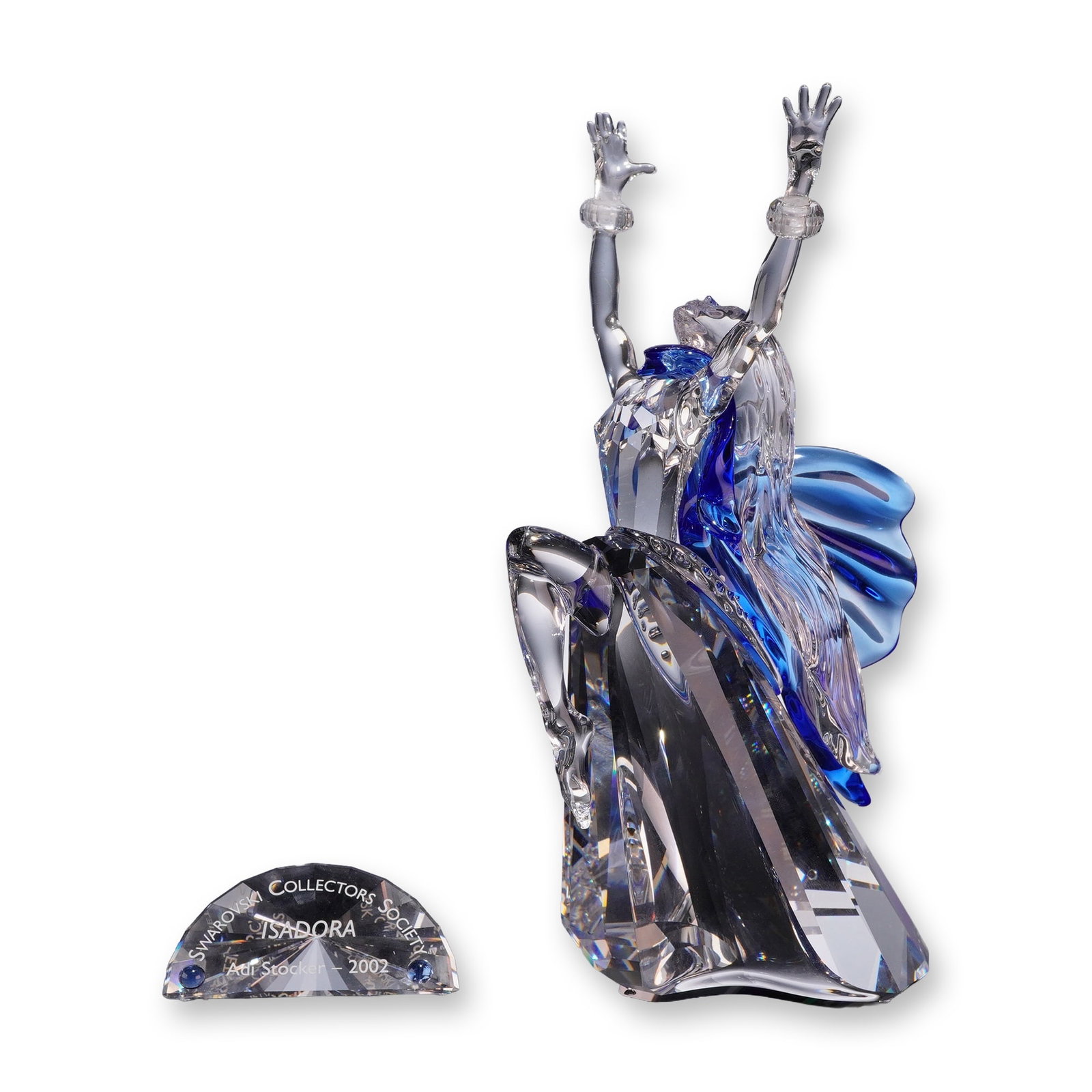 Swarovski 2002 Annual Edition Crystal Figurine, Magic of Dance Isadora and Title Plaque: Swarovski Collectors Society 2002 Annual Edition crystal figurine titled Isadora, designed by Adi Stocker as part of the Magic of Dance trilogy. The faceted clear crystal figure depicts a dynamic danc