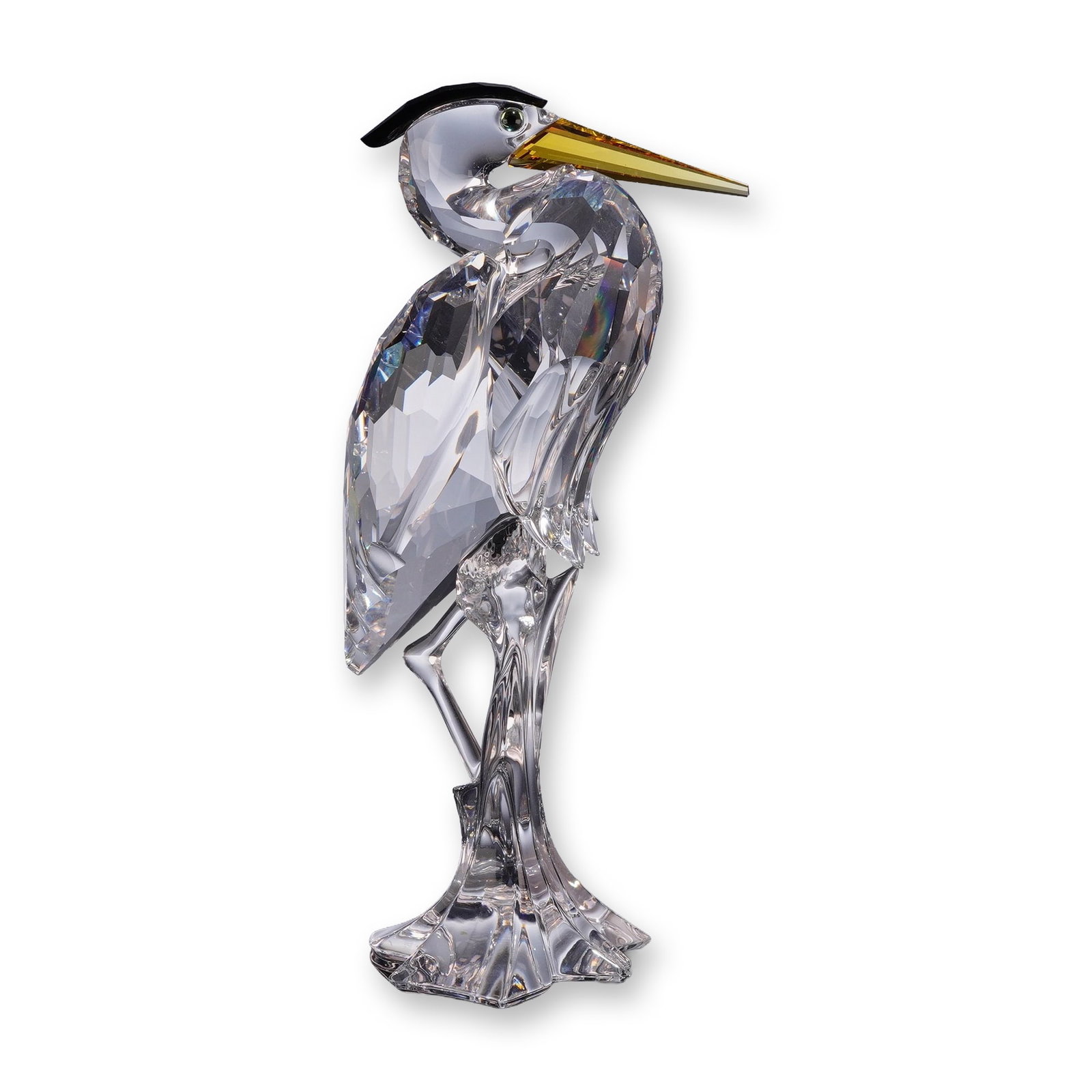 Swarovski Crystal Figurine, Silver Heron: Swarovski Silver Crystal heron figurine featuring a faceted clear crystal body perched on a textured crystal reed-like base. The bird is designed with a contrasting yellow-amber crystal beak, a black 