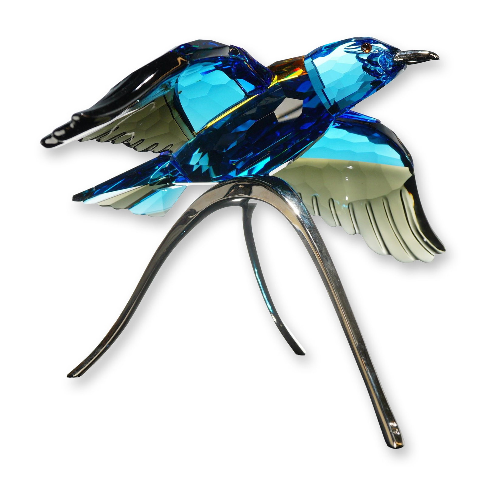 Swarovski Crystal Paradise Roller Bird Figurine: Swarovski. Paradise Birds Roller Bird figurine, model 957568, in multi-colored faceted crystal. The stylized bird is depicted in flight with a vibrant blue head and tail, turquoise-blue wings with smo