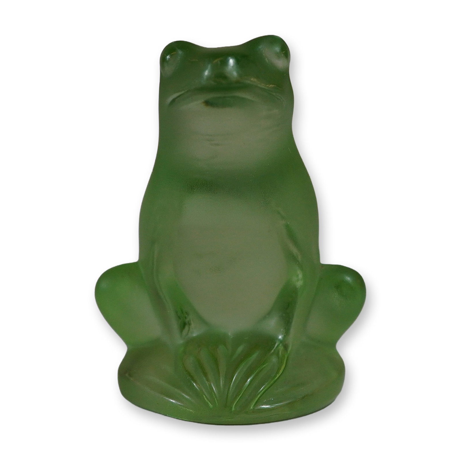 Lalique Frosted Green Glass Rainette Frog: Lalique, France. A small Rainette frog figurine in frosted green art glass. The molded figure is depicted in a seated position on a stylized circular lily pad base, featuring a smooth satin-finished t