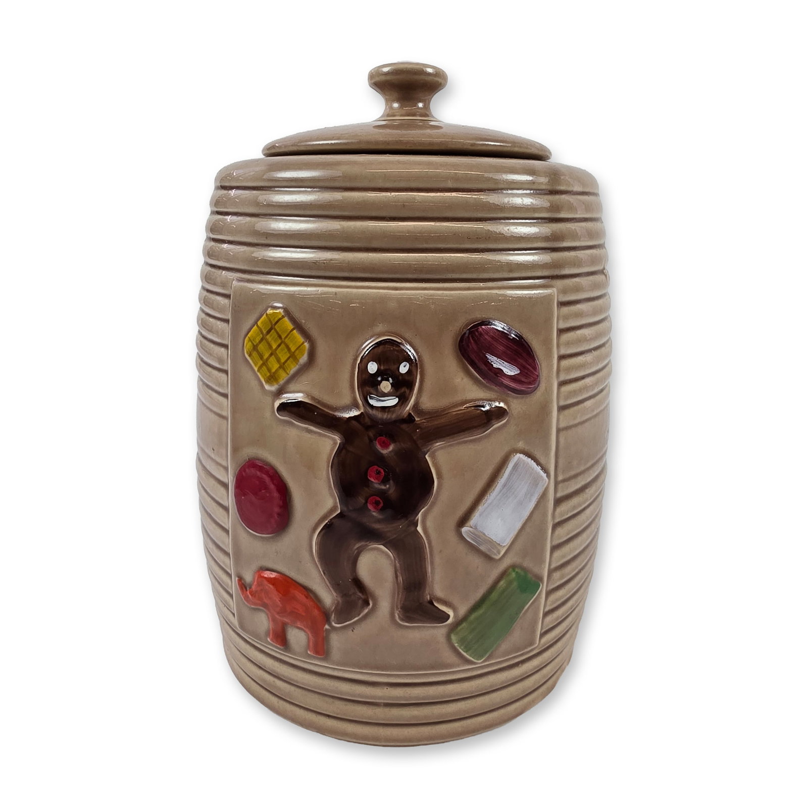 McCoy Dancing Gingerbread Man Cookie Jar: American art pottery lidded cookie jar, by McCoy, mid-20th century. Earthenware vessel designed in a barrel form with horizontal ribbing and a recessed relief-molded panel. The decoration depicts a da