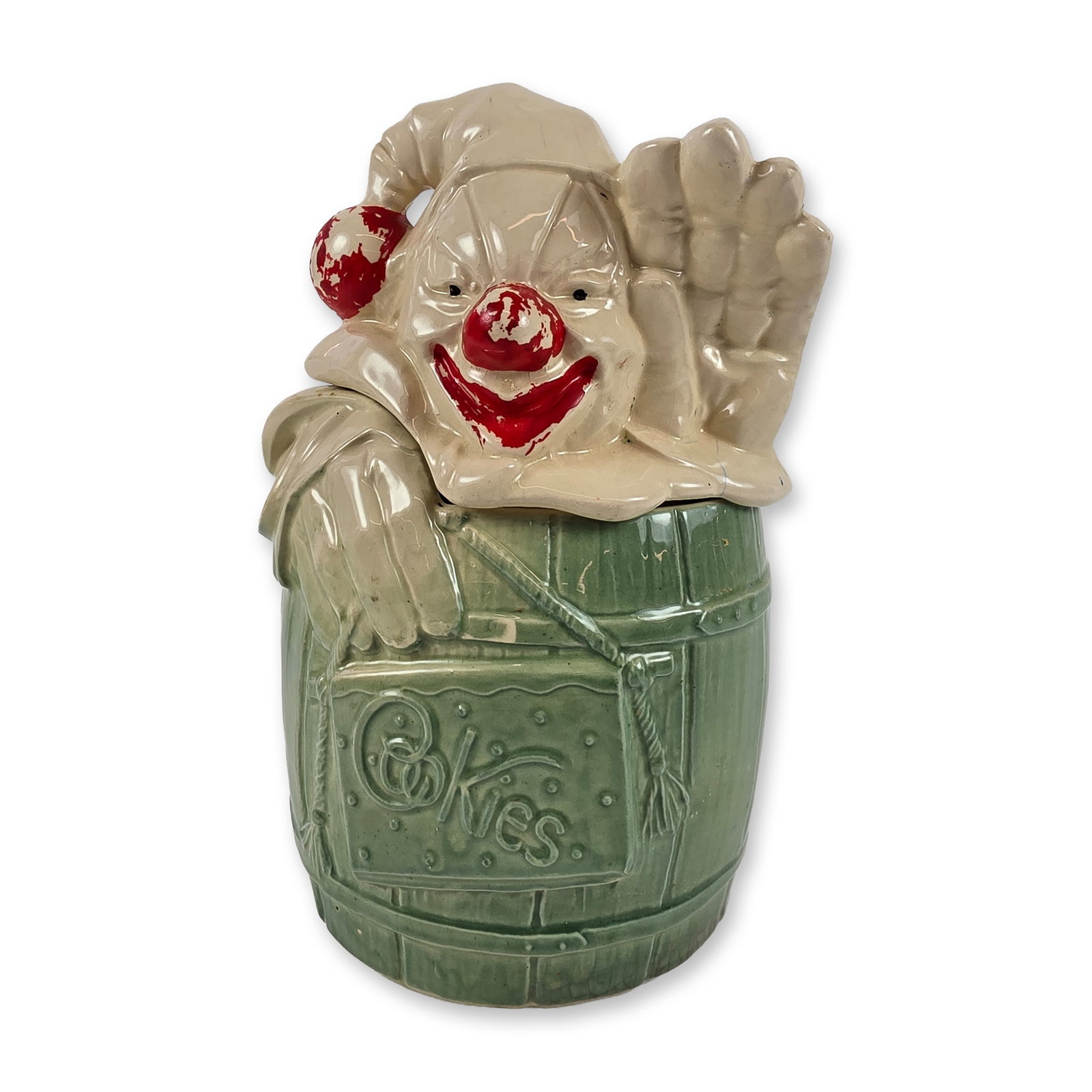 McCoy Pottery USA Ceramic Clown Cookie Jar: Glazed earthenware cookie jar in the Clown in Barrel form. The barrel-shaped base features a mottled green glaze and an embossed rectangular panel on the front with the word Cookies in stylized script
