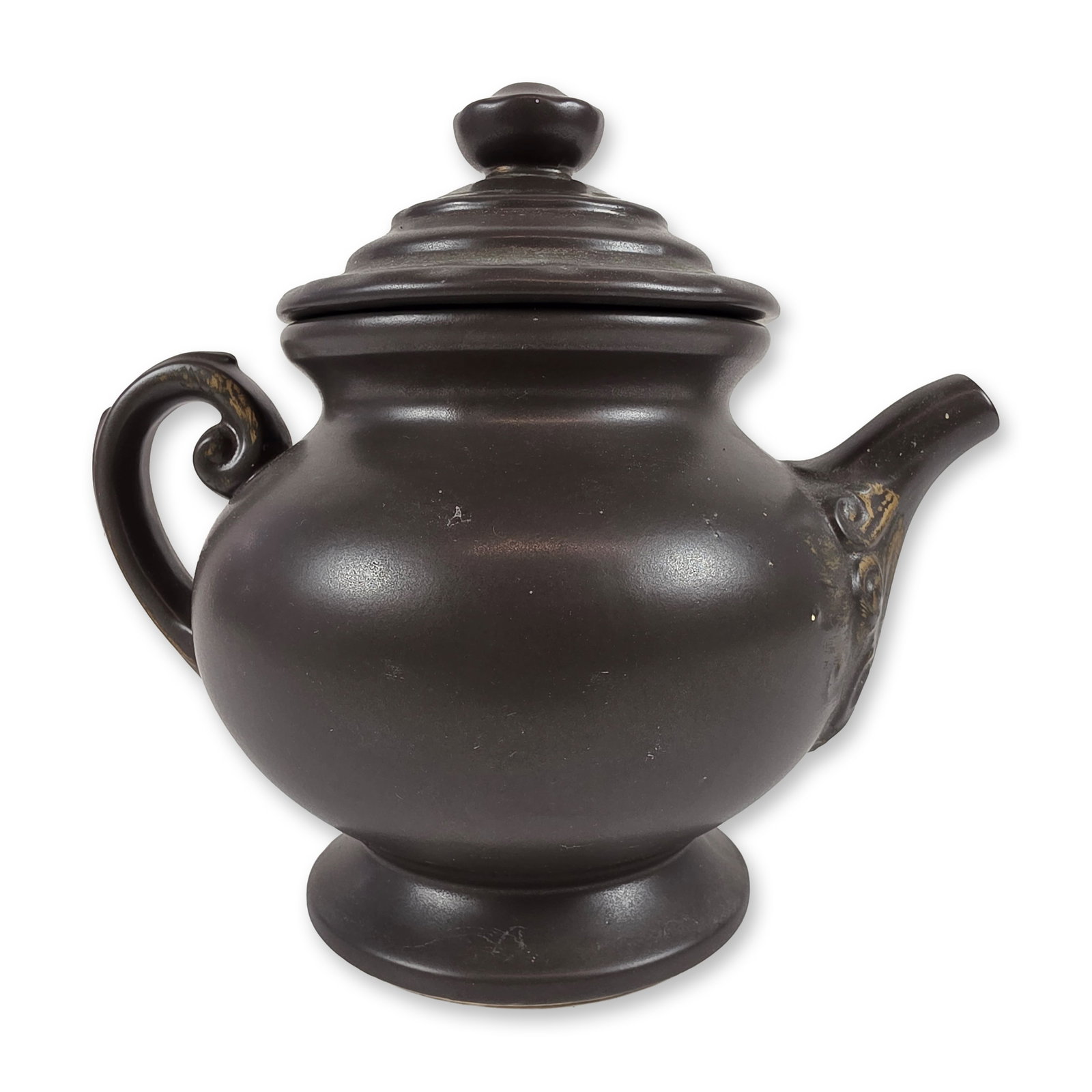 McCoy Pottery Teapot Cookie Jar: Teapot form cookie jar in earthenware, featuring a pedestal base, S-scroll handle, and fitted lid with a spherical finial. The vessel body is molded with an embossed decorative cartouche containing th