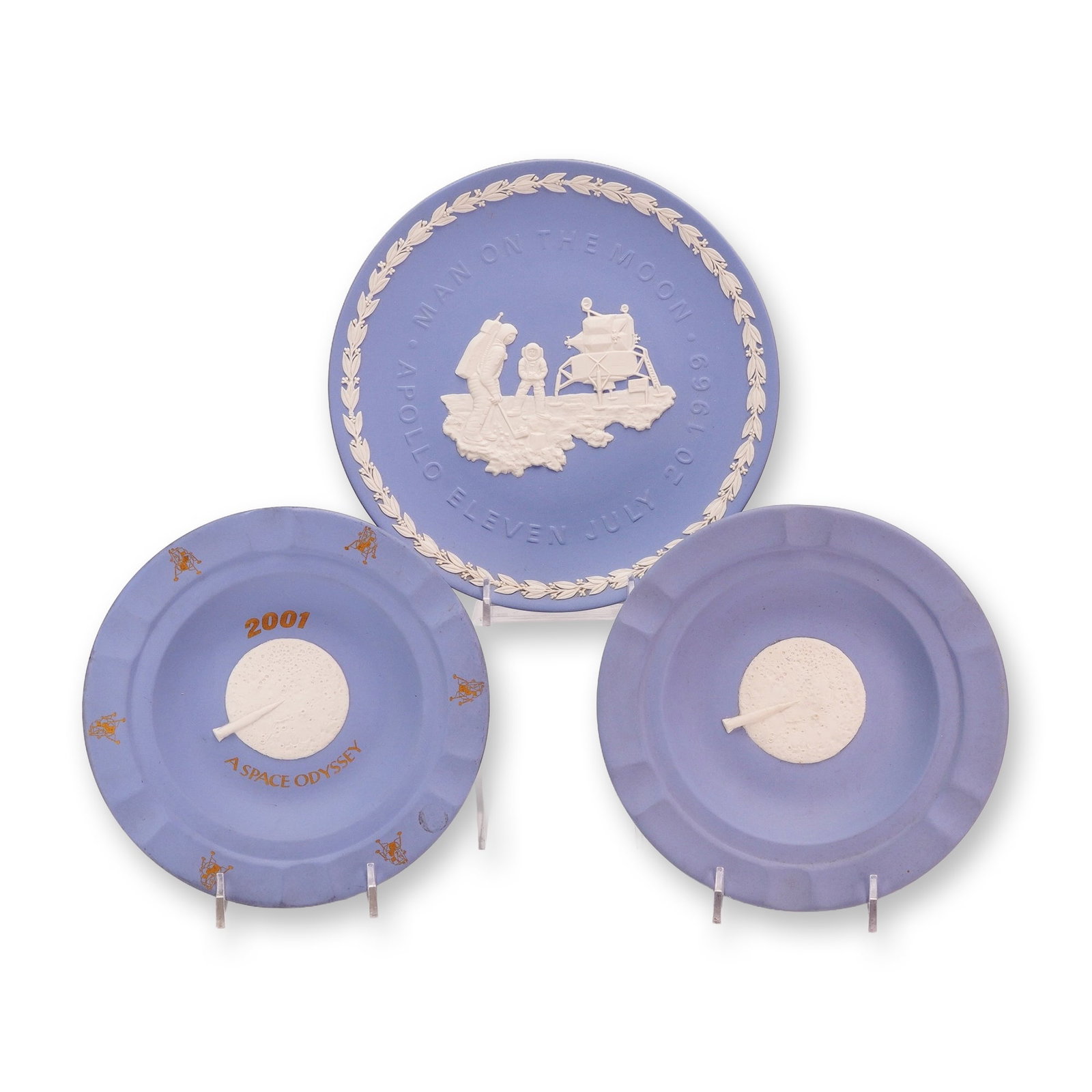 3pc Wedgwood Blue Jasperware Space Exploration and Cinema Commemorative Items: This collection consists of three pieces of blue jasperware manufactured by Wedgwood in England, featuring themes related to the 1969 moon landing and the film 2001: A Space Odyssey. The set includes 