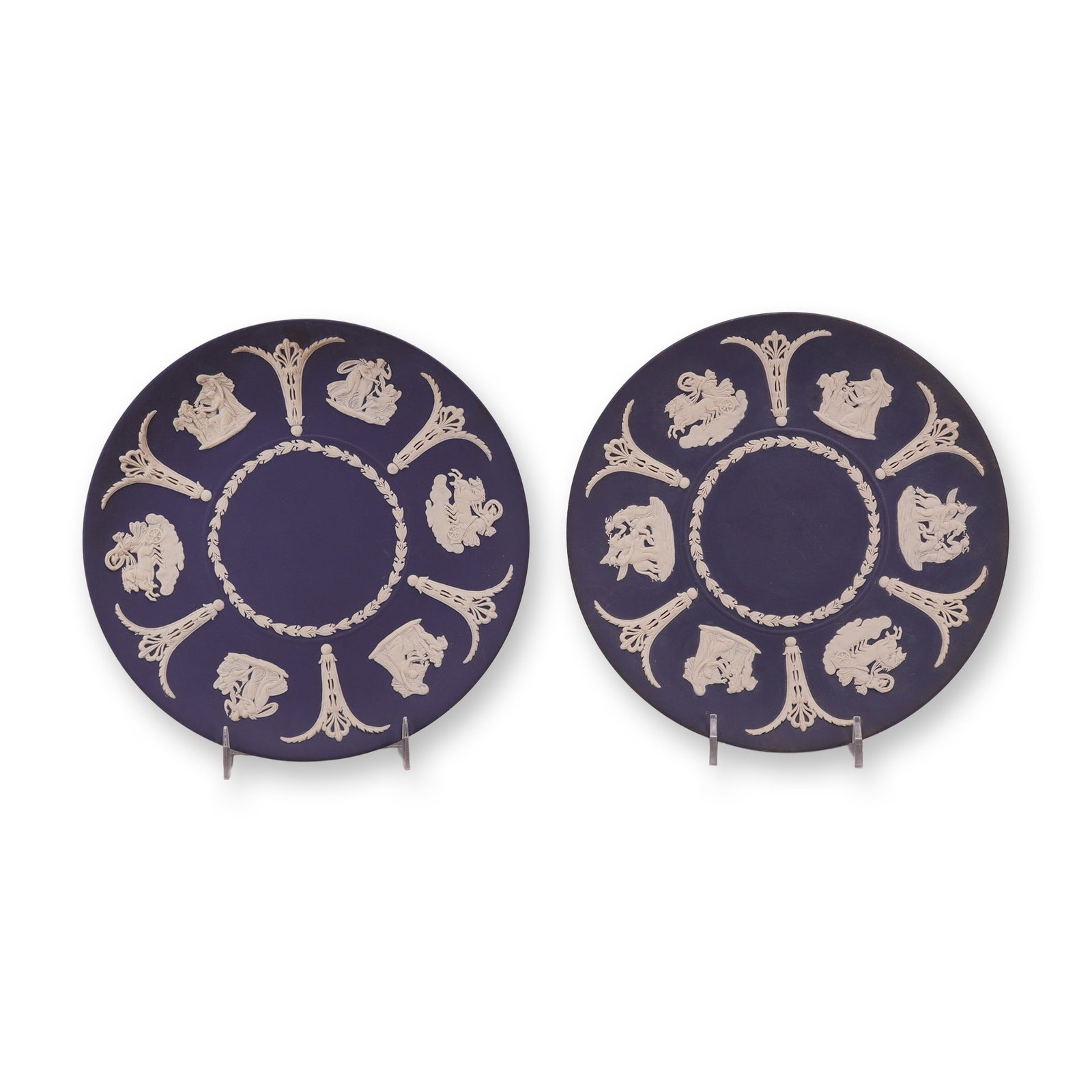 Two Wedgwood Cobalt Blue Jasperware Classical Plates from the Rubin Collection: This pair of circular cabinet plates is composed of jasperware, a matte unglazed stoneware manufactured by Wedgwood in England. The pieces feature white sprigged bas-relief decoration applied to a dee