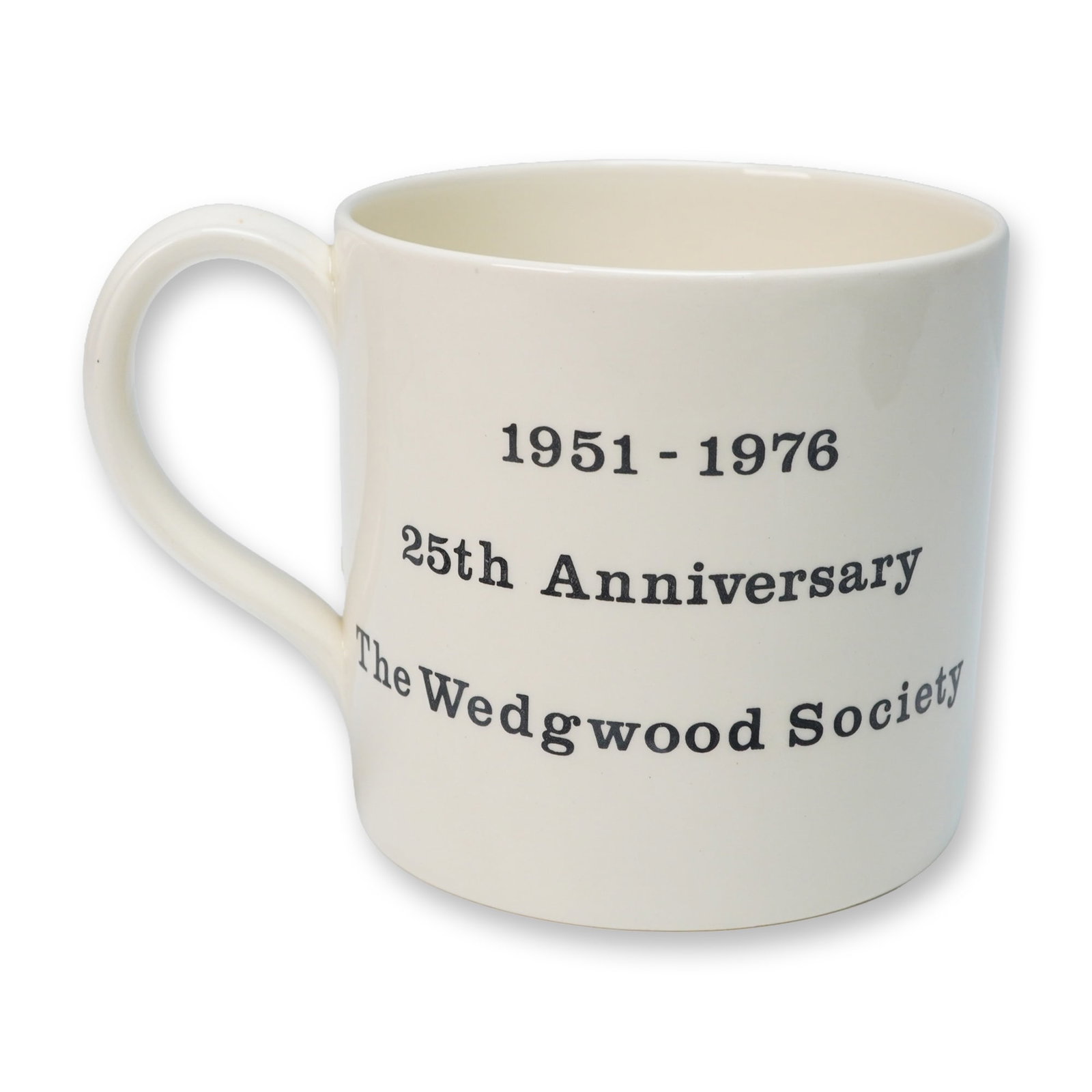 A Wedgwood Society 25th Anniversary Commemorative Mug: A cream-colored, glazed ceramic mug with a single handle by Wedgwood. The front is decorated with black printed text reading "1951 - 1976", "25th Anniversary", and "The Wedgwood Society". The reverse 