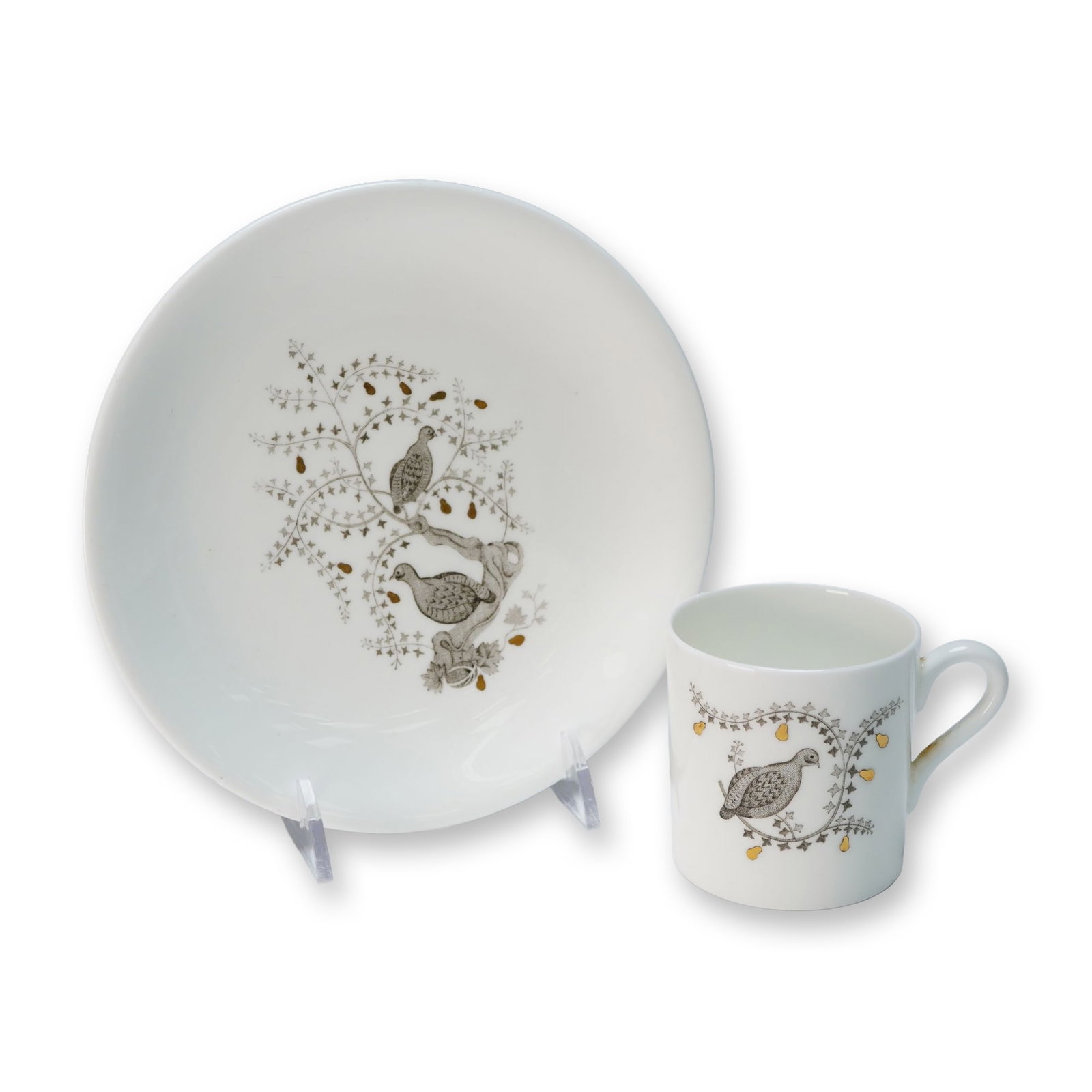 A Wedgwood 'Partridge In A Pear Tree' Bone China Cup and Saucer Set: A Wedgwood 'Partridge In A Pear Tree' cup and saucer set, crafted from bone china. Both pieces feature a stylized naturalistic motif depicting one or two grey and brown partridge-like birds nestled am