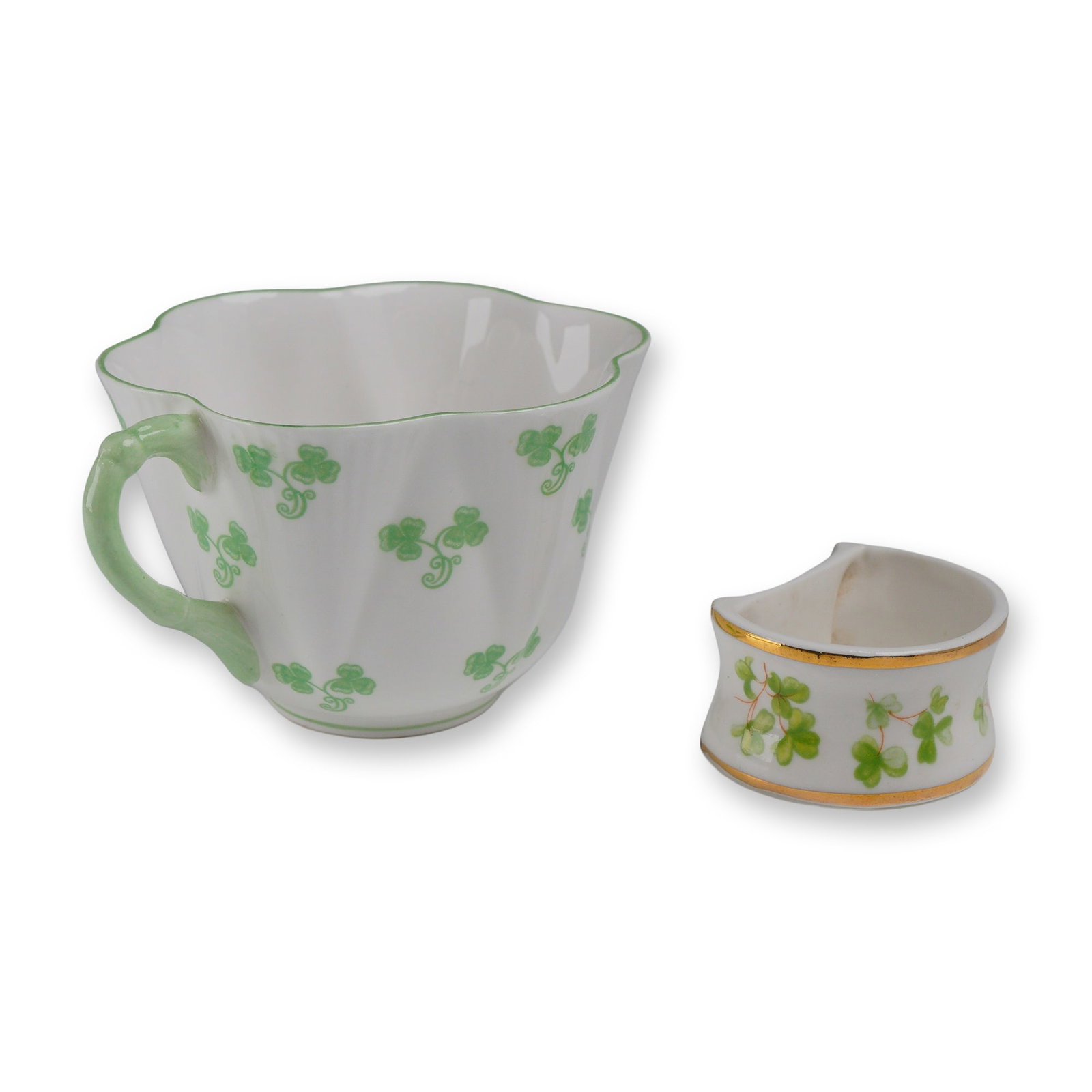 2pc Shelley and Lane End Shamrock Cup and Napkin Ring: This lot consists of two pieces of English fine bone china featuring traditional shamrock motifs. The first item is a Shelley teacup in the iconic "Dainty" shape, distinguished by its fluted