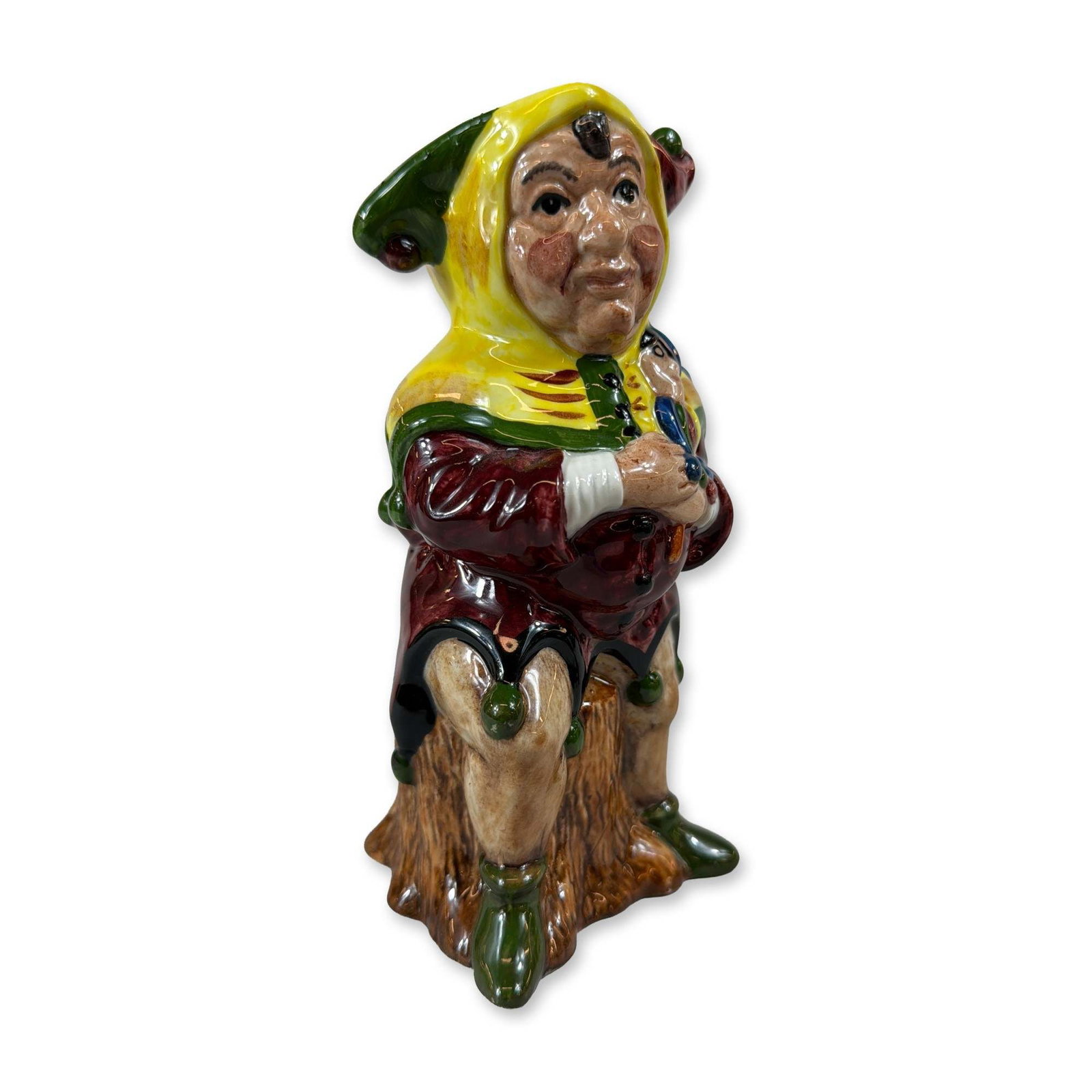Staffordshire Fine Ceramics Touchstone Toby Jug: Staffordshire Fine Ceramics glazed ceramic toby jug depicting Touchstone from William Shakespeare's As You Like It. The hand-painted standing figure is modeled against a textured tree trunk, wearing a