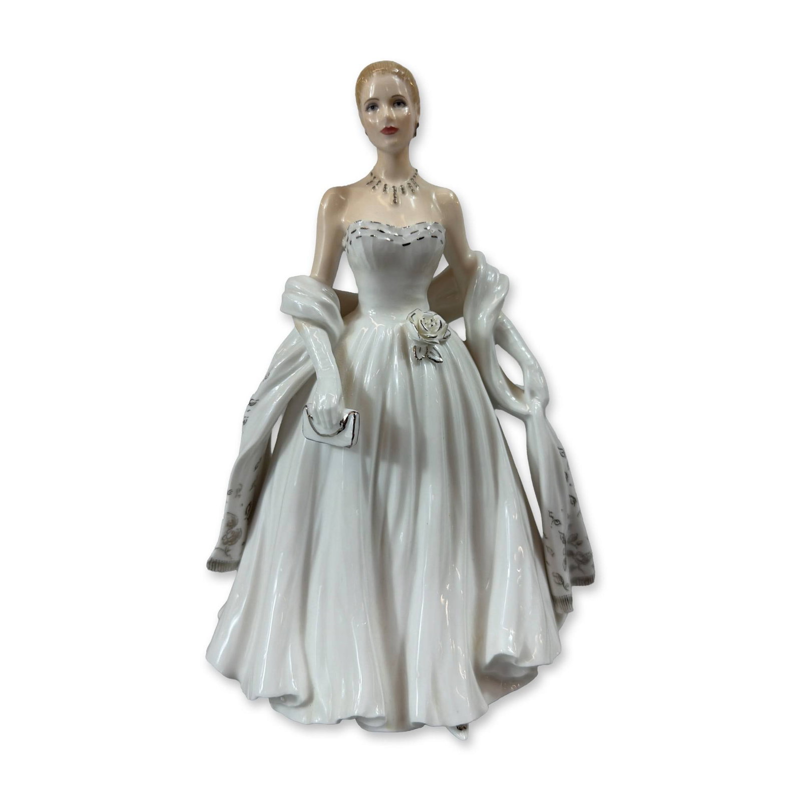 Royal Worcester Grace Kelly Porcelain Figurine: A Royal Worcester fine bone china figurine depicting Grace Kelly, sculpted by Jack Bromley. The figure is modeled standing in a strapless white evening gown with a flared skirt, detailed with a silver