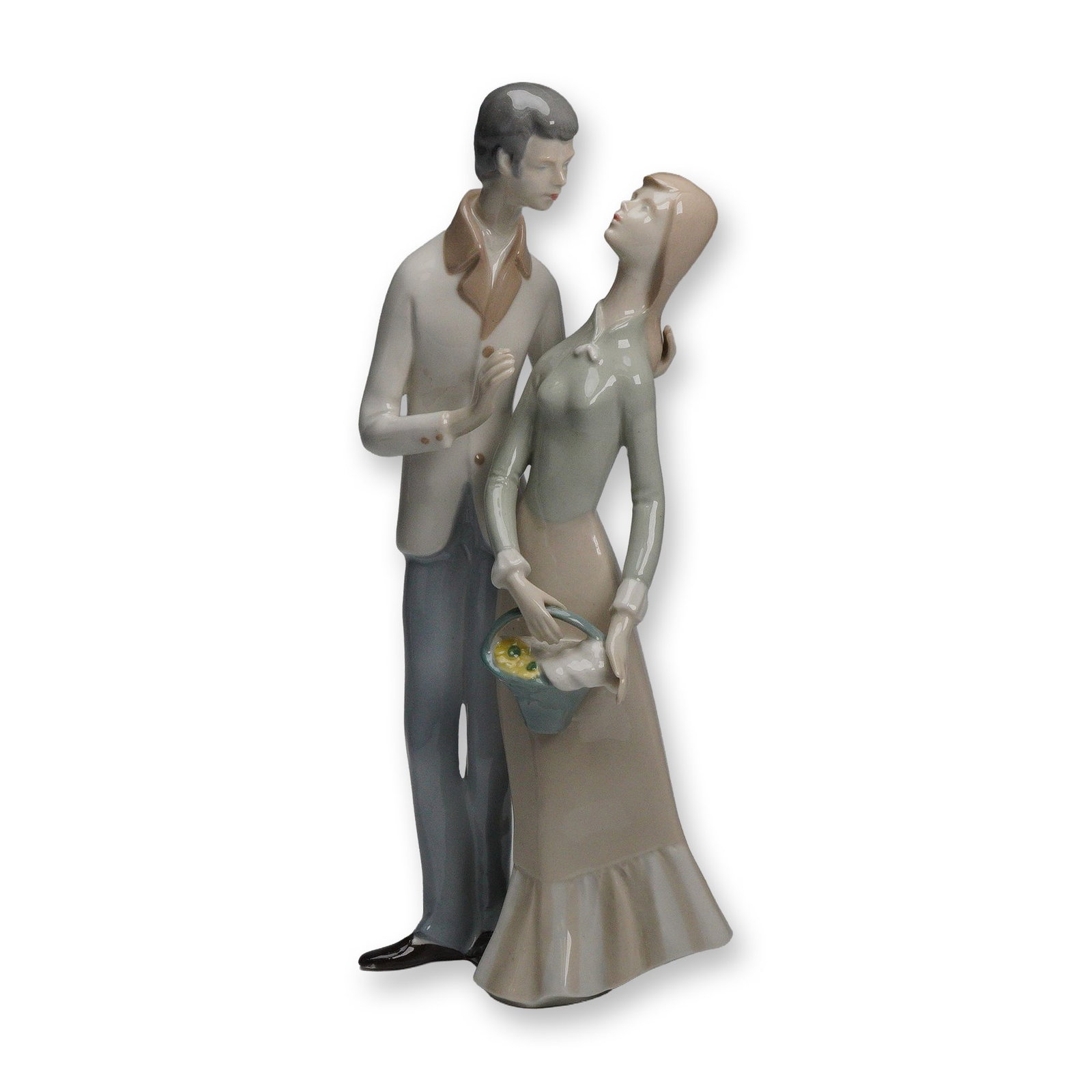 GDR Lippelsdorf Young Couple Porcelain Figurine: A glazed porcelain figurine from Lippelsdorf in the German Democratic Republic depicting a young couple standing closely together, the woman holding a small basket of yellow flowers and dressed in a l
