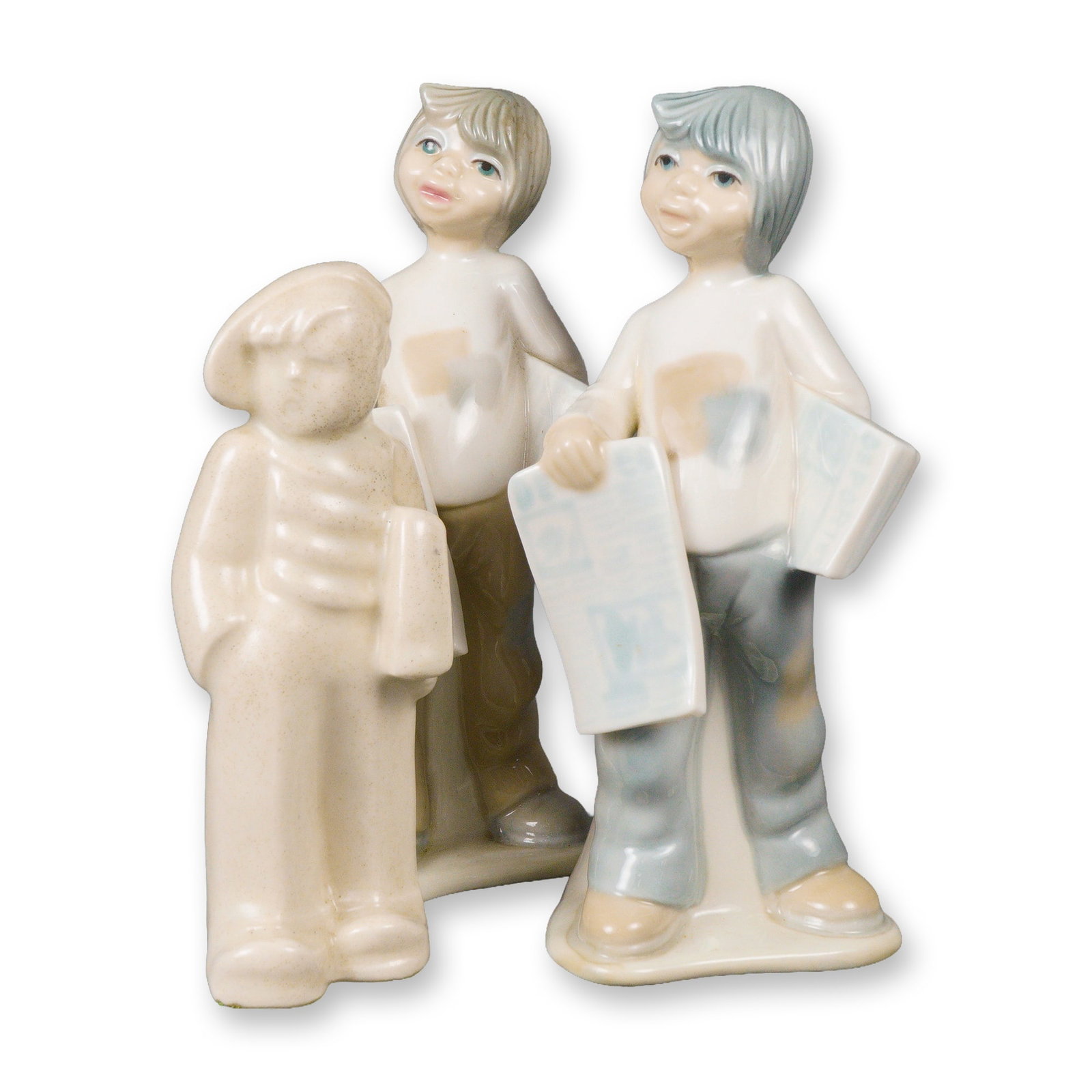 Three Tengra Ceramic Newspaper Boys Figurines: Three ceramic figurines depicting boys holding newspapers. Two glazed and hand painted figures are by Tengra of Spain, modeled in soft cream, blue, tan, and flesh tones with simplified features and ca