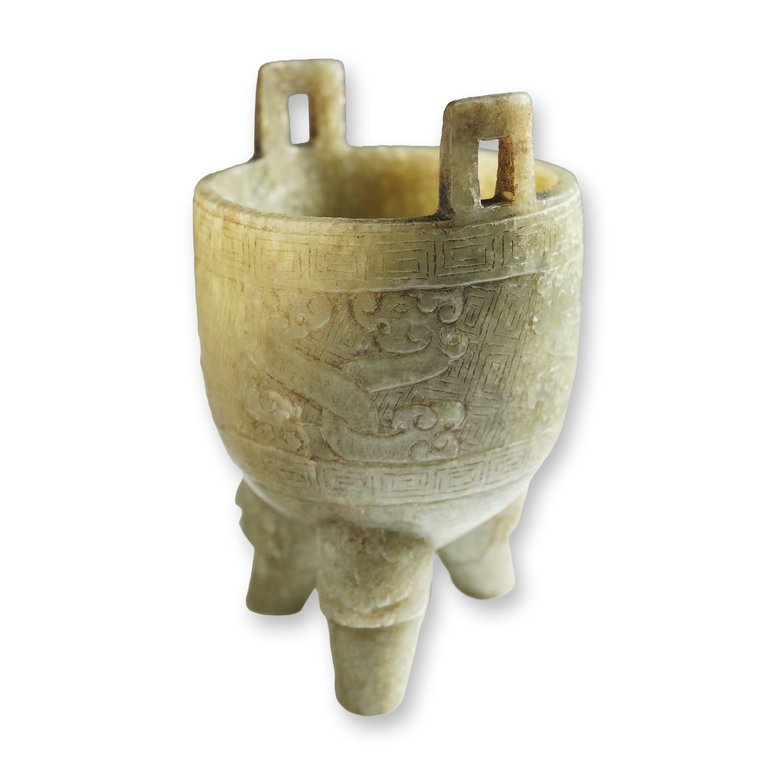 Chinese Ming Jade Archaic-Style Tripod Vessel: Small tripod vessel carved from pale green stone. The vessel is supported on three sturdy legs and features two rectangular handles extending vertically from the rim. The exterior surface is decorated