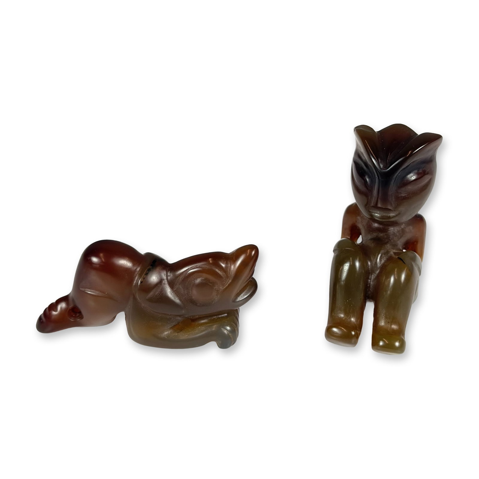 2pc Carved Stone Figural Amulet Figurines in the Hongshan Culture Style: This lot consists of two small, hand-carved hardstone figures rendered in the style of ancient Chinese Hongshan culture artifacts. The first figure is a stylized humanoid depicted in a seated position