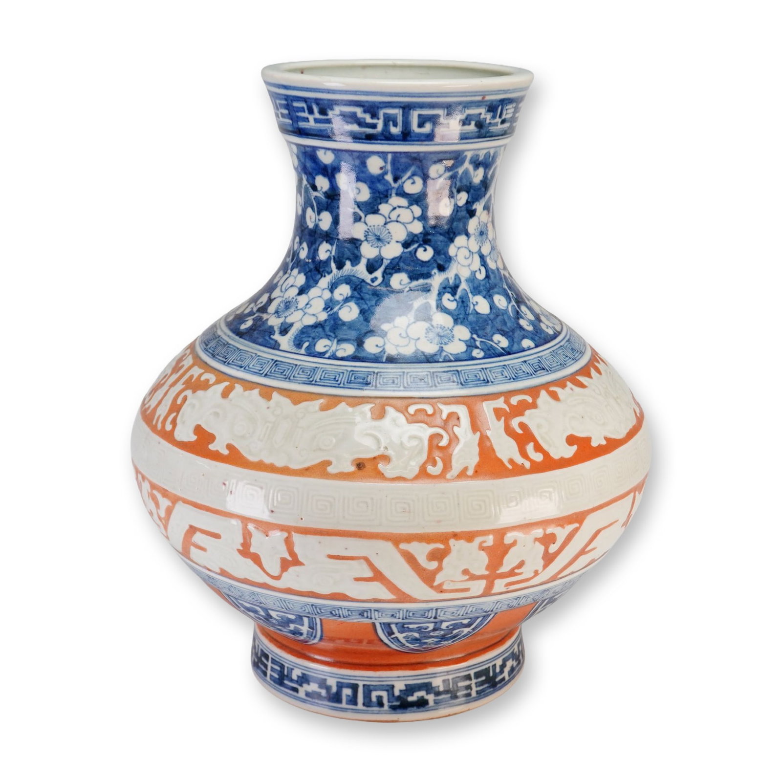 Chinese Blue and White Porcelain, Molded Taotie Masks, Hawthorne Pattern: Chinese white and blue vase with a bulbous body, flared neck, and orange detailing, featuring molded Taotie masks and a Hawthorne floral motif. Dimensions: 11"W x 13.25"H Weight: 10 lbs