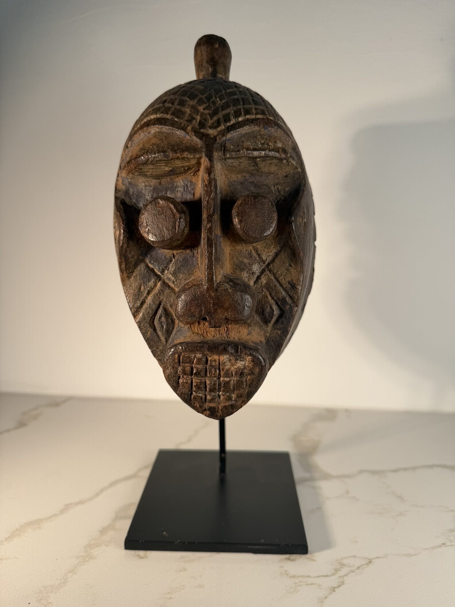 Ijo Water Spirit Headdress Mask, Nigeria, 19th Century: A single Ijo Water Spirit headdress mask, attributed to the late 19th century and originating from Nigeria. This ceremonial mask is carved from dark, heavily patinated wood and features a concave face