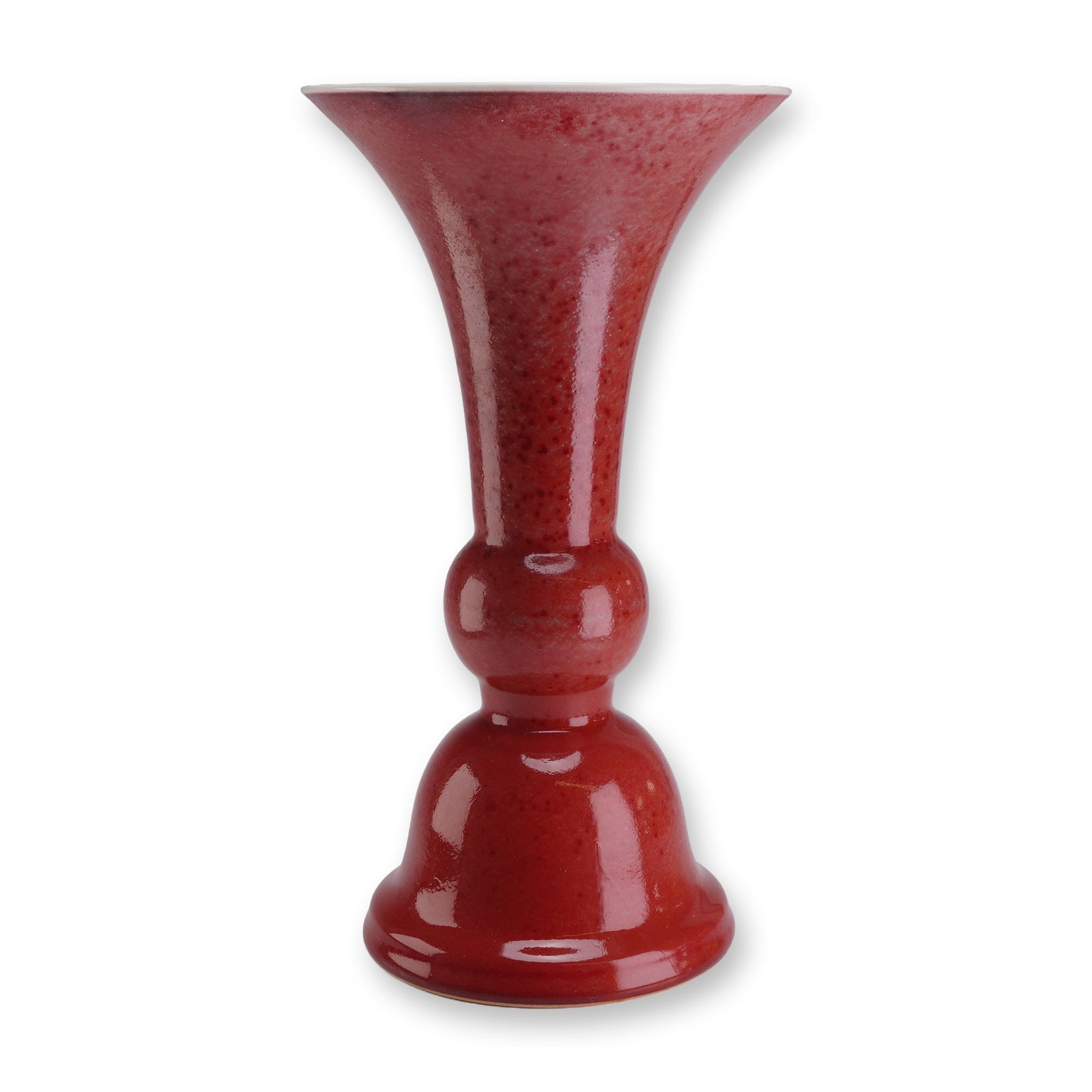 Qing Dynasty Qianlong Peachbloom Trumpet Vase: A Chinese porcelain vase of trumpet form, featuring a widely flaring mouth and neck, a bulbous central knop, and a spreading, bell-shaped foot. The exterior is covered in a mottled copper-red glaze wh
