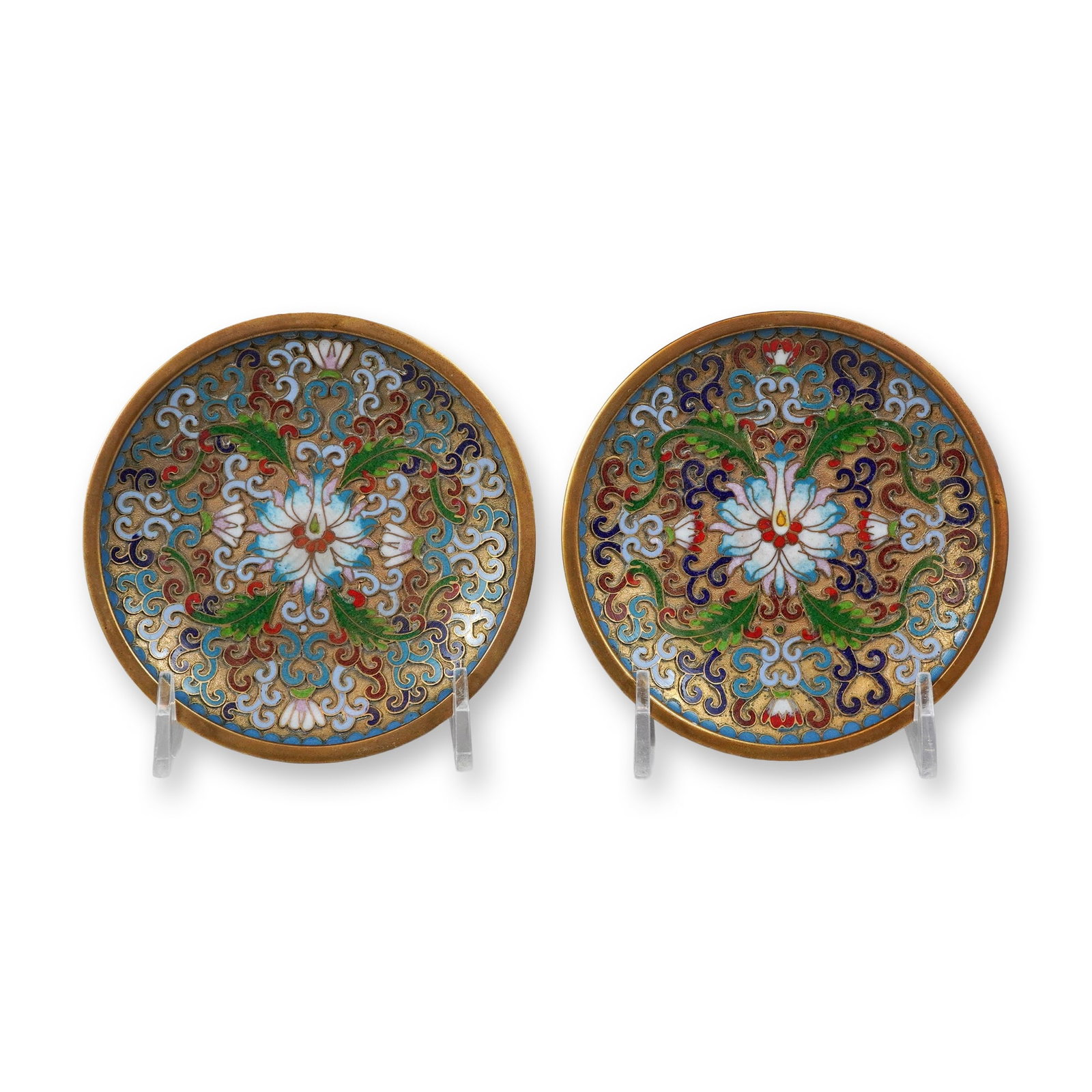 A Pair of Chinese Cloisonne Enamel Small Dishes: This matching pair of small, circular dishes is decorated with intricate cloisonne enamel work on a copper alloy base. The interior of each dish is centered with a large lotus blossom in shades of whi