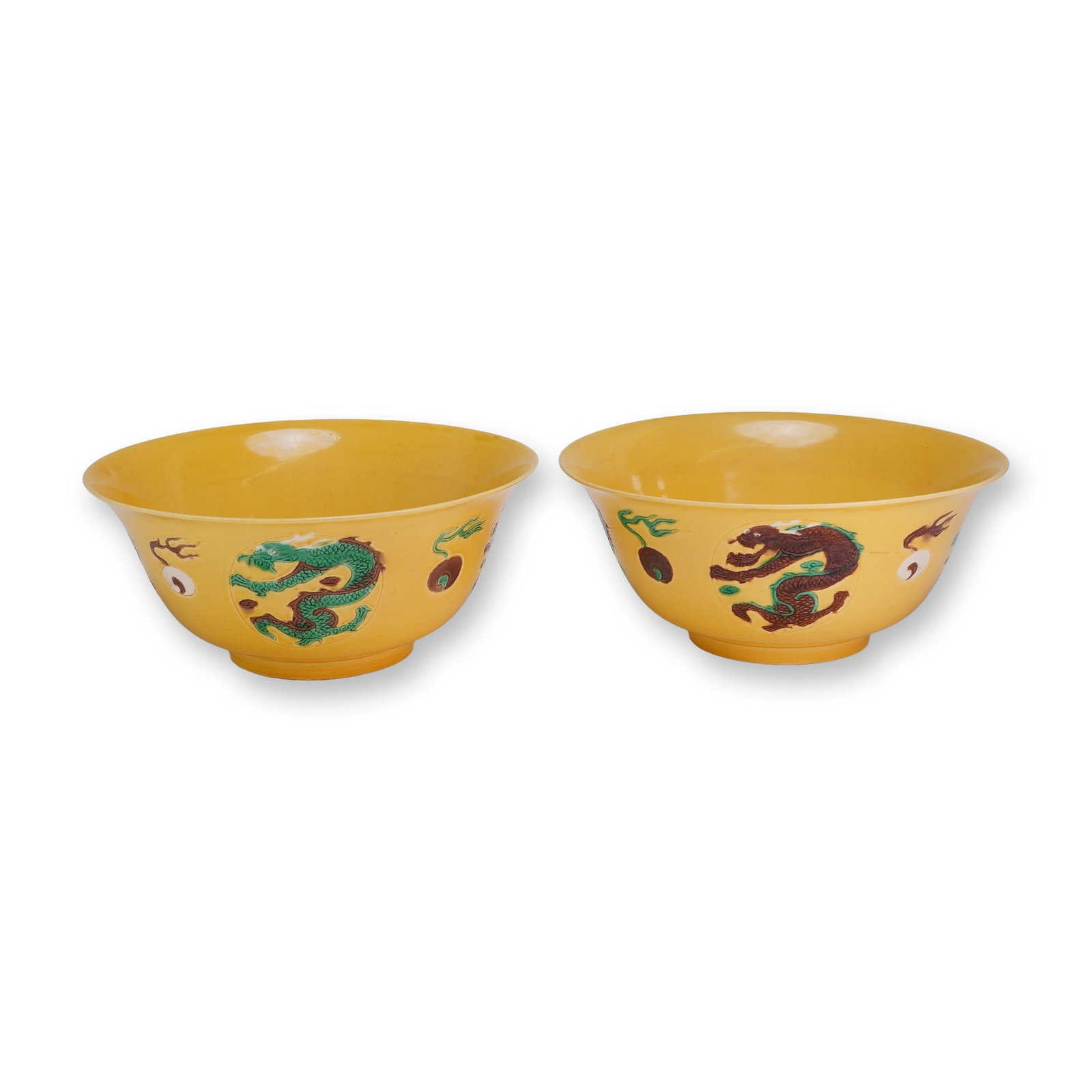 Pair of Yellow Glaze Bowls, Kangxi Mark, Dragons and Flaming Pearls: A pair of yellow glazed bowls decorated with dragons and flaming pearls in shades of brown, green, and white. Each bears Kangxi marks on the underside. Dimensions: Each: 7.75"W x 3.5"H Weight: 2.8 lbs