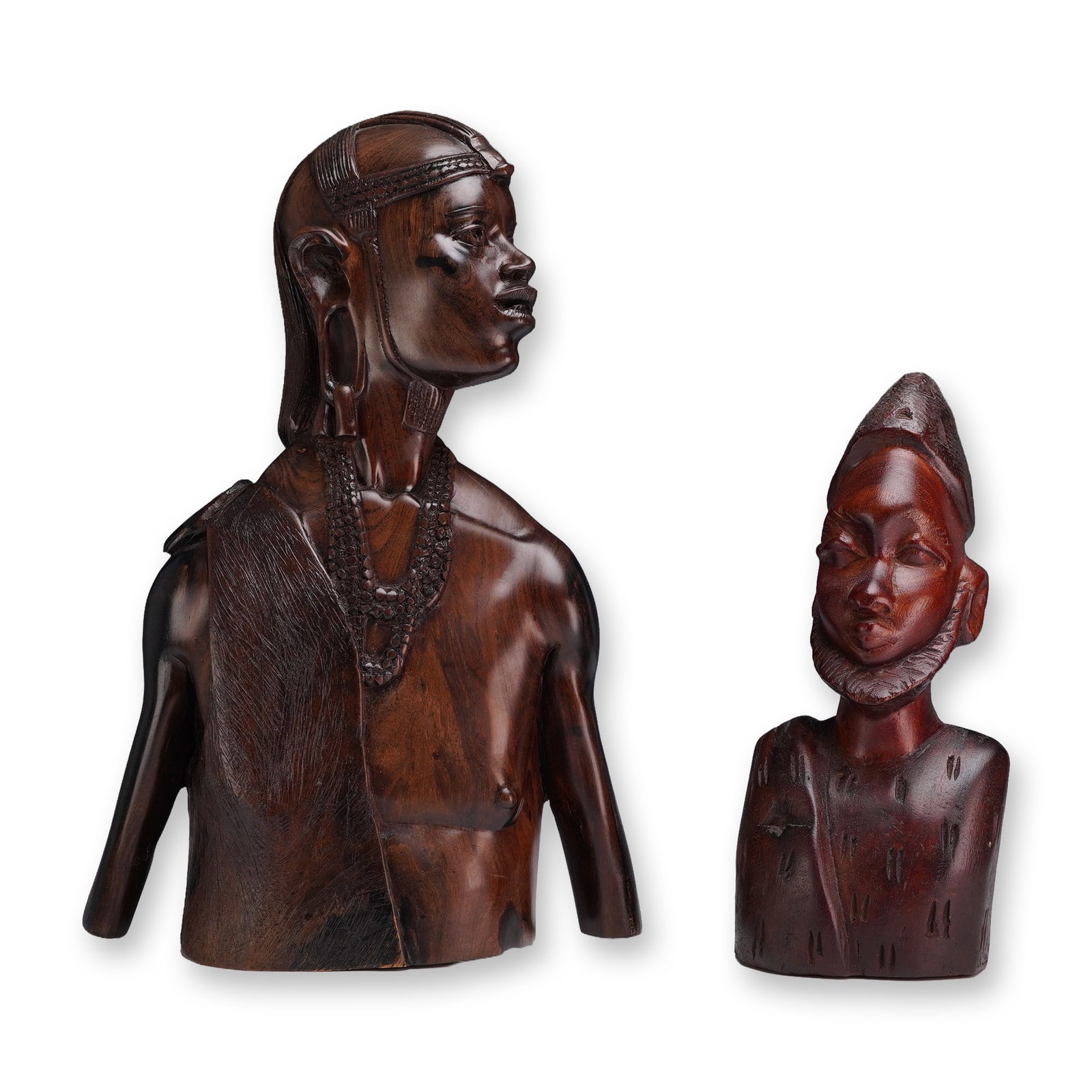 2pc African Ebony Wood Carved Figures: This group of hardwood busts are hand-carved from dense, polished ebony wood with a deep, dark patina. The larger bust depicts a figure with a finely detailed hairstyle, a decorative headband, and elo