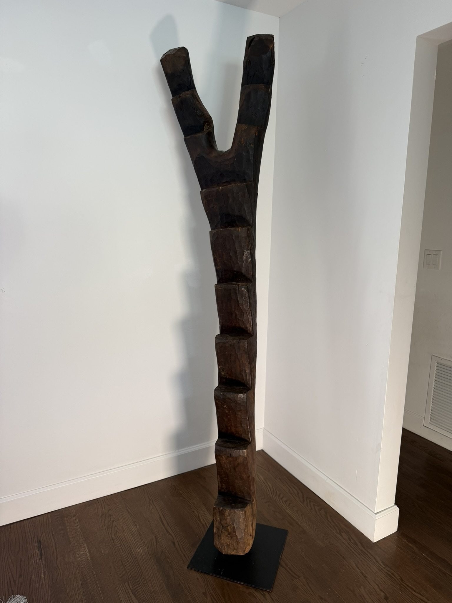 Dogon Wooden Ladder, Mali, 20th Century: Hand-carved from a single tree trunk, this wood Dogon ladder from Mali exemplifies the iconic utilitarian and symbolic forms created by the Dogon people, featuring notched steps and a distinctive Y-sh
