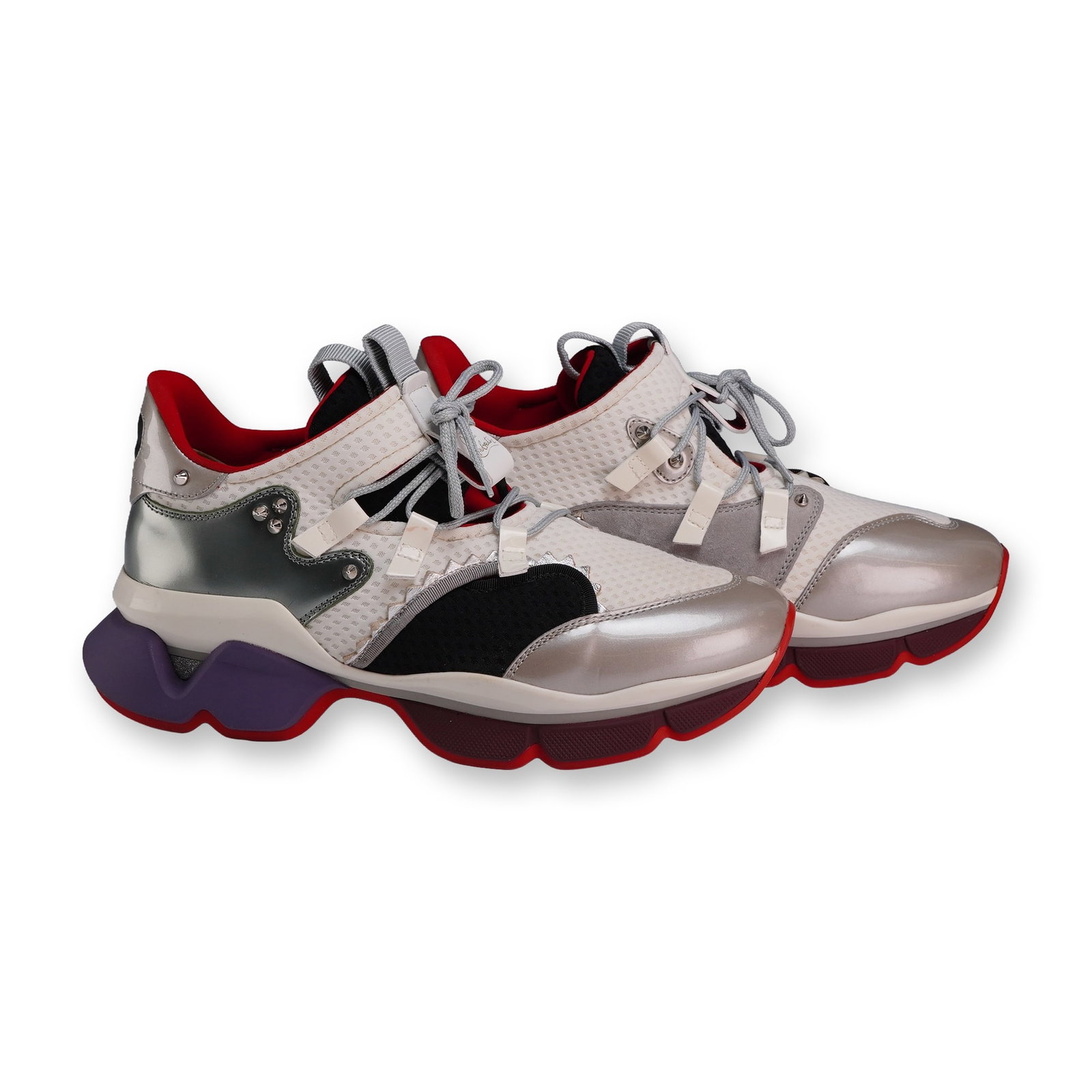 Christian Louboutin Red-Runner Metallic White Sneakers: A pair of Red-Runner sneakers in the Metallic White colorway, featuring white mesh and metallic silver-tone uppers with gray suede accents and signature metal spikes. Built on a multi-layered chunky s