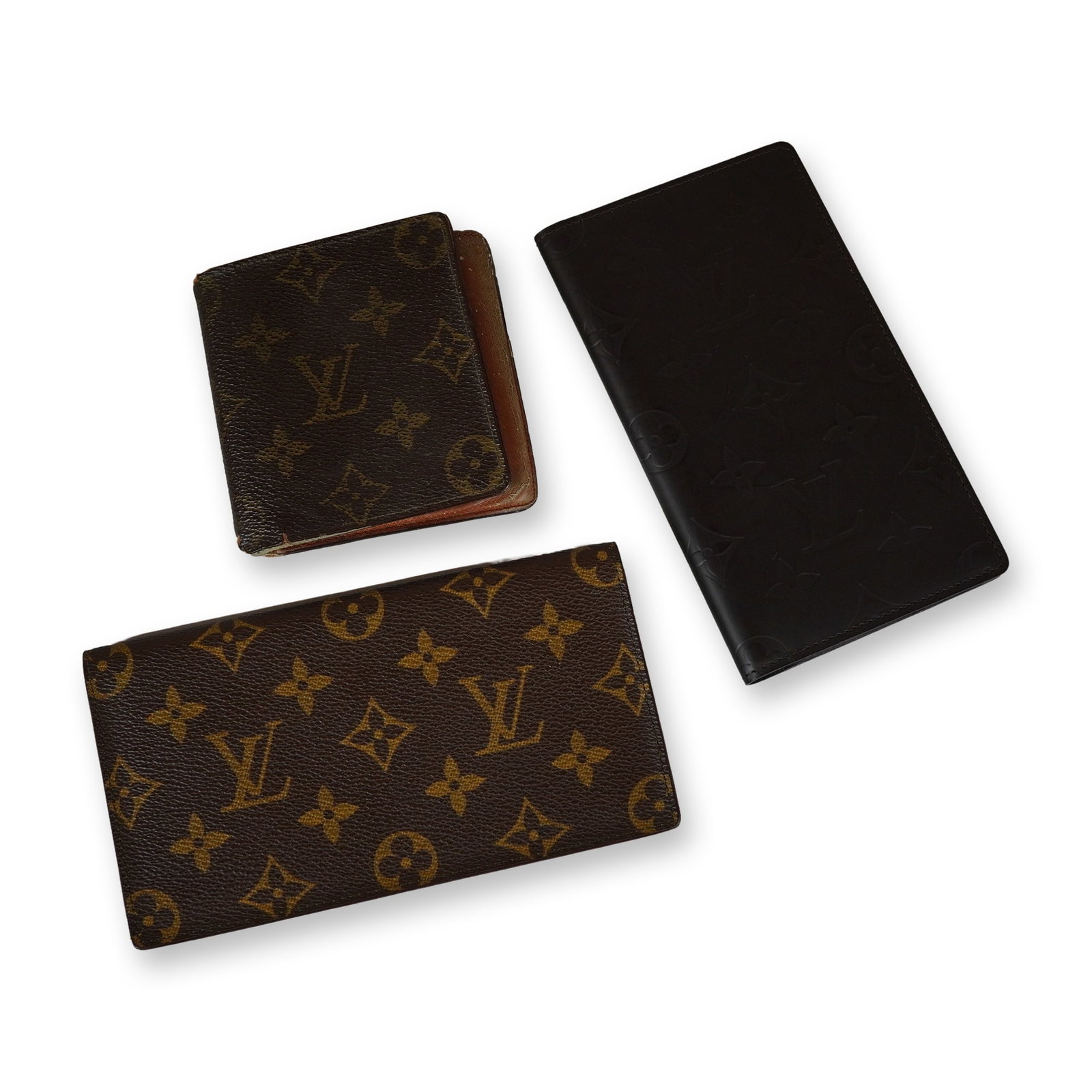 Three Louis Vuitton Monogram and Leather Wallets: Louis Vuitton. Collection of three wallets, including two long profile billfolds and one compact bifold wallet. The group includes a long wallet crafted from black leather with an embossed Monogram pa