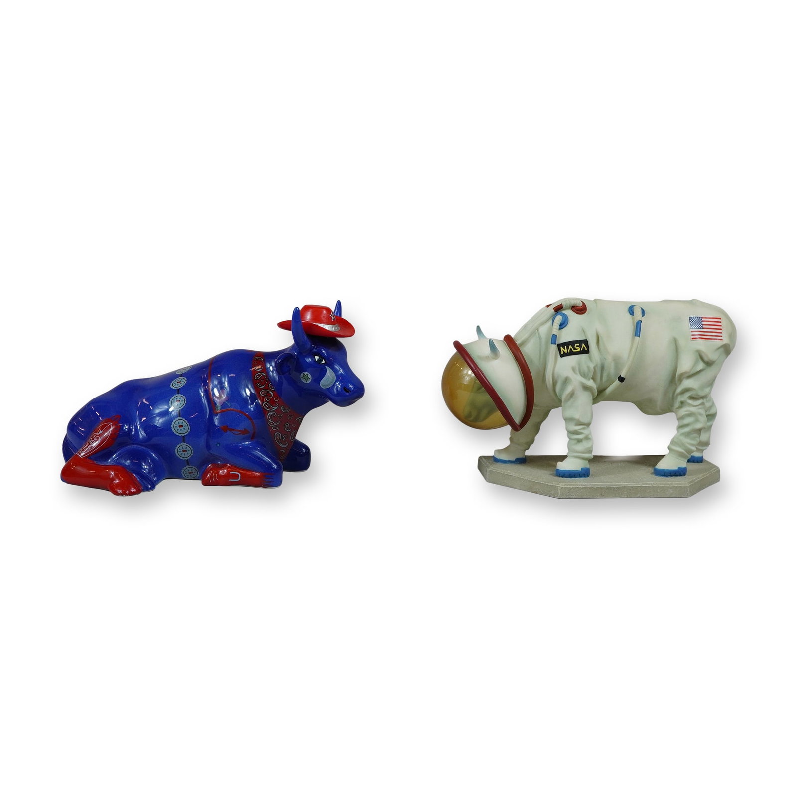 Two CowParade Moooooonwalk and Cowboy Figurines: A pair of art figurines in the Moooooonwalk and cowboy cow motifs. The seated cowboy bull, item number 9180, is a glazed ceramic figure in cobalt blue with red accents, featuring a cowboy hat, bandana
